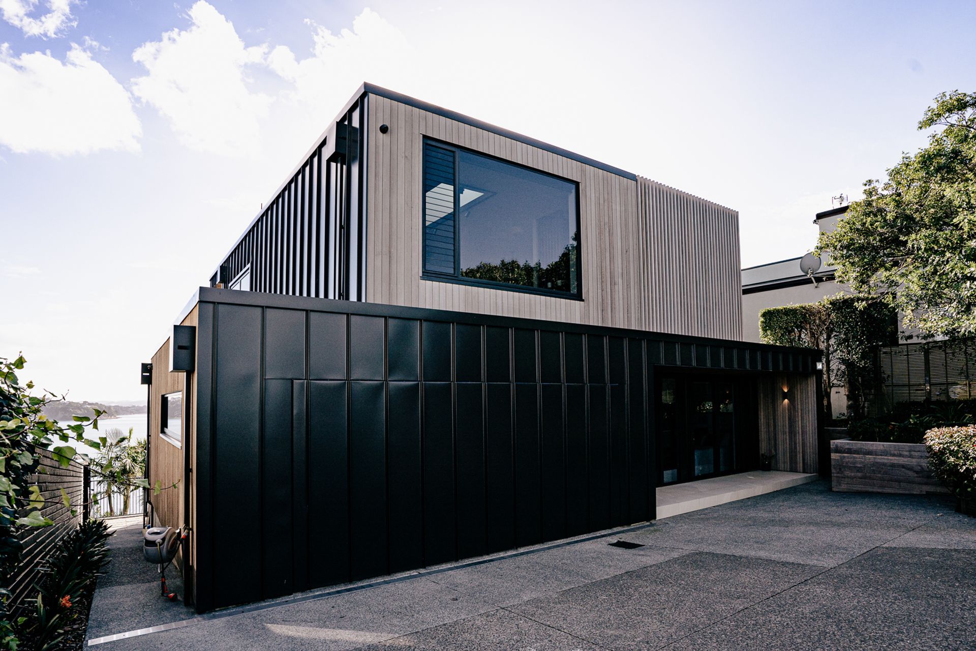 The entrance of the house showcases the two primary cladding materials used for the home.