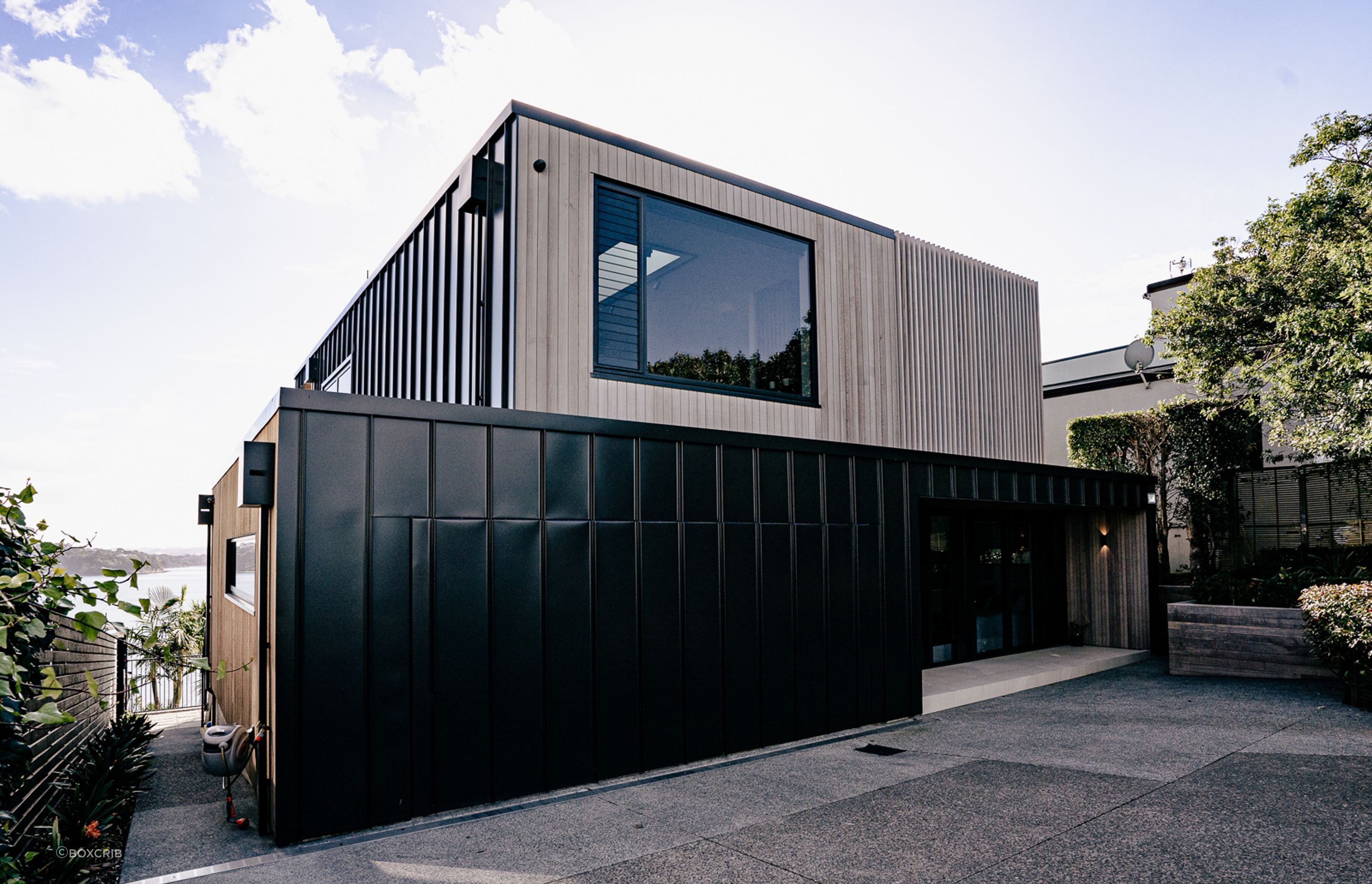 The entrance of the house showcases the two primary cladding materials used for the home.