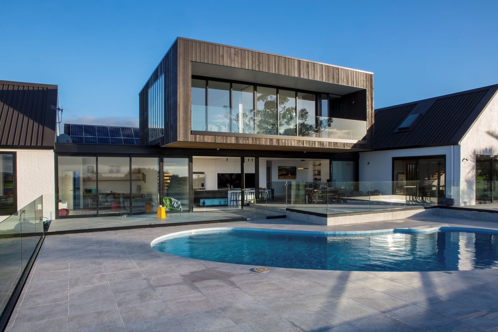 A modern take on a kidney-shaped pool in this stylish home in Whitford. | Photography: Emma-Jane Hetherington