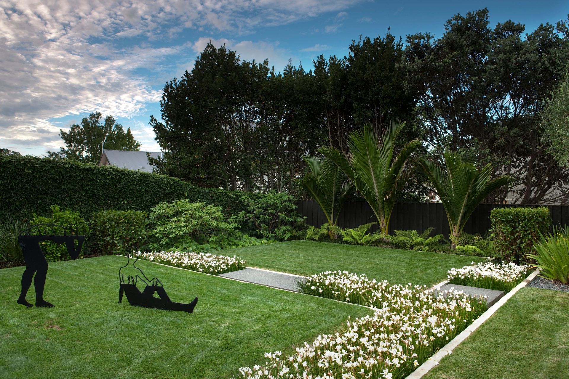 Second Nature uses lush flower beds to divide space in this suburban backyard.