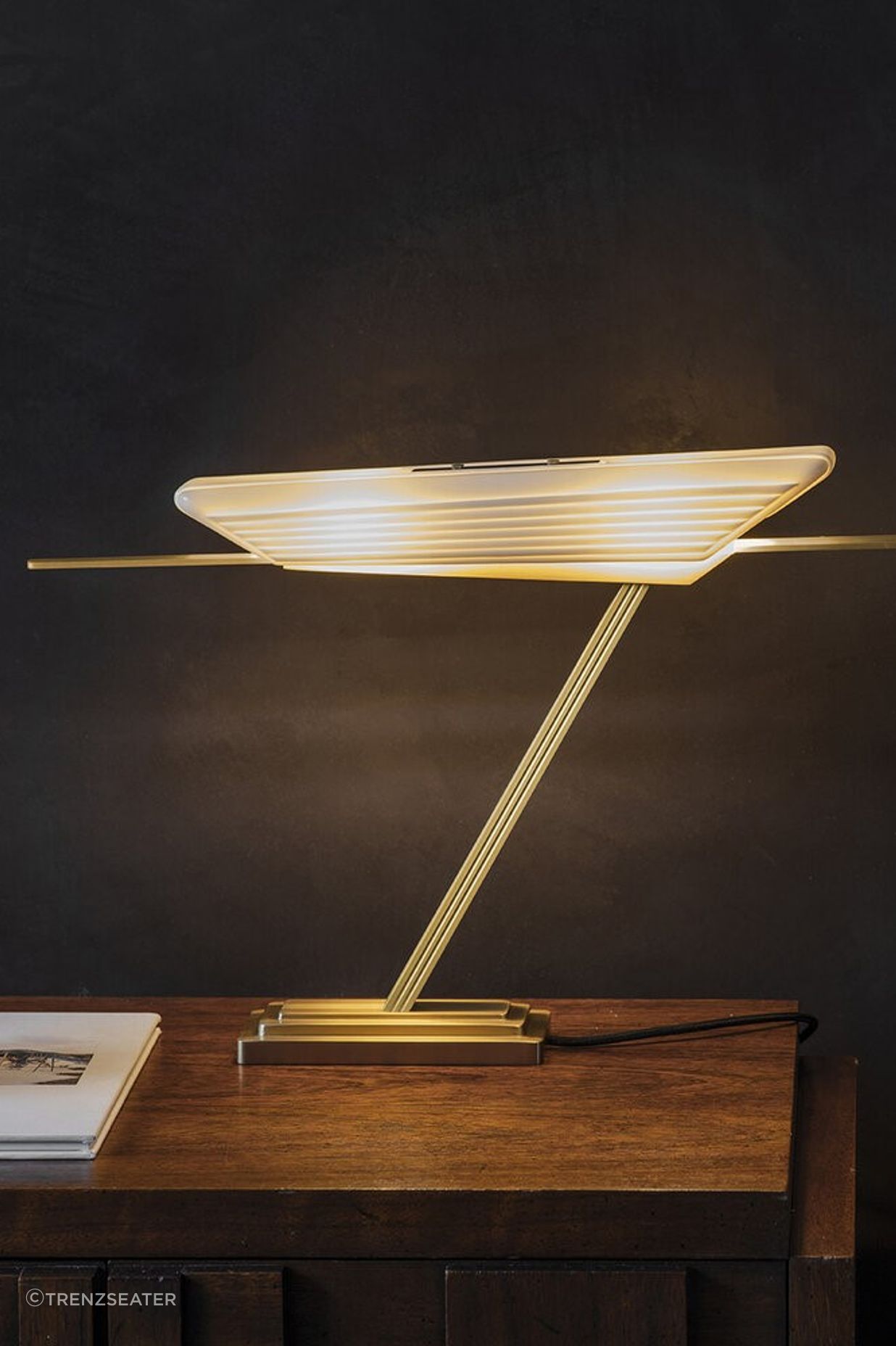 Exquisite materials that include a bone fine china shade and brass base with the Glaive Table Lamp