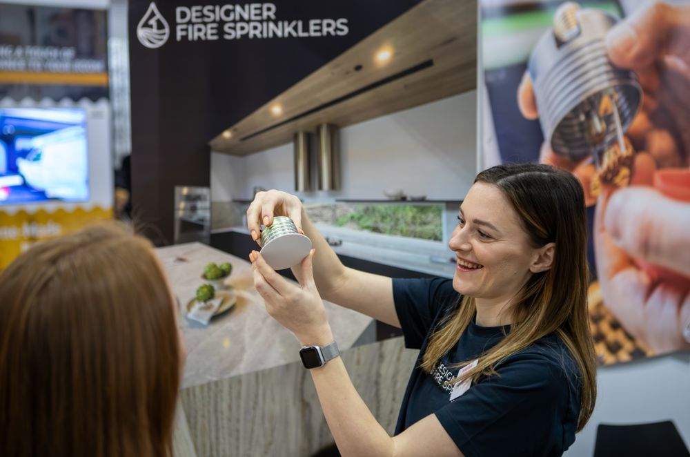 Designer Fire Sprinklers' managing director and co-founder Sionainn Hayes shows off a sprinkler unit at a home show.