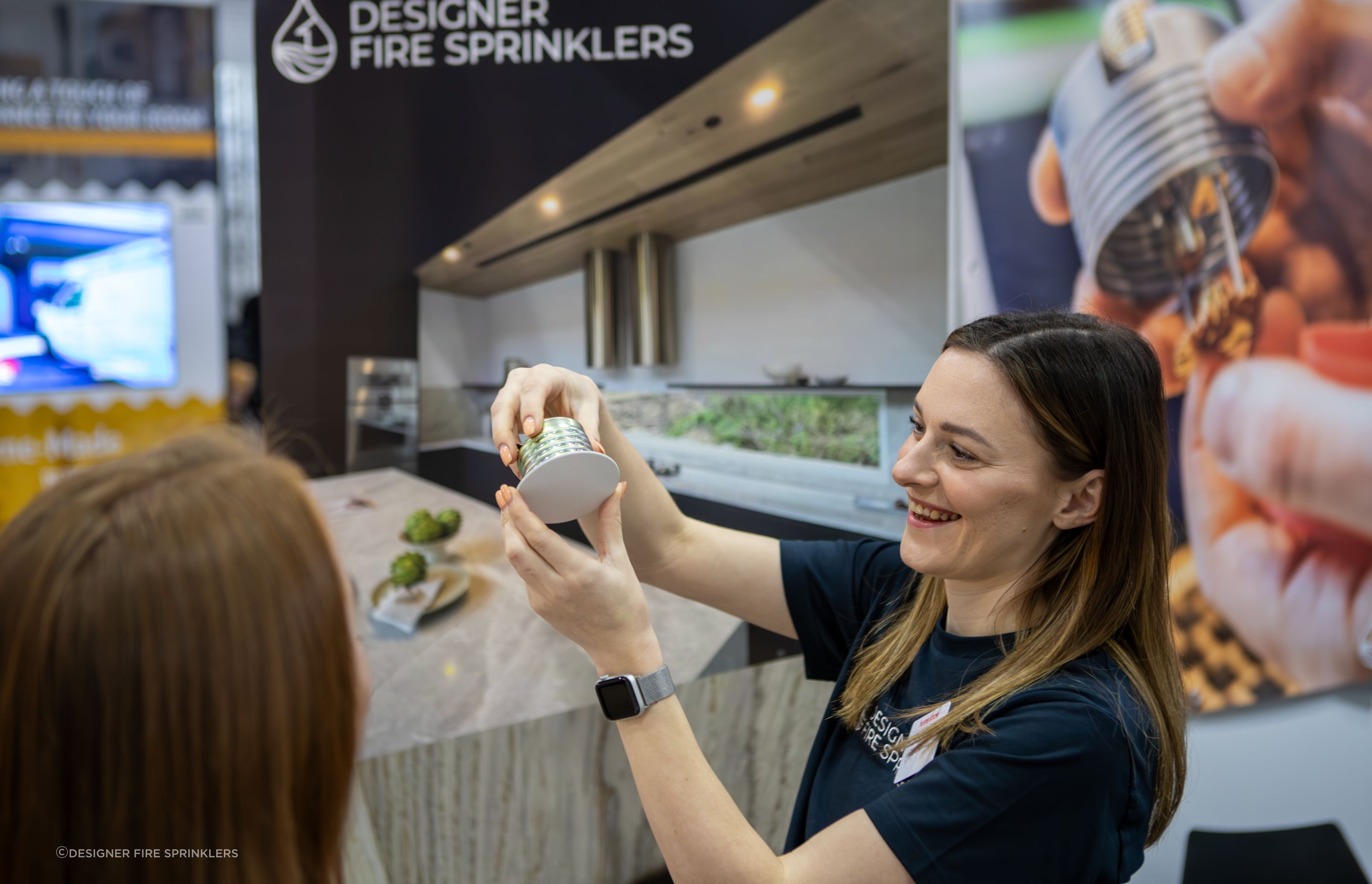 Designer Fire Sprinklers' managing director and co-founder Sionainn Hayes shows off a sprinkler unit at a home show.