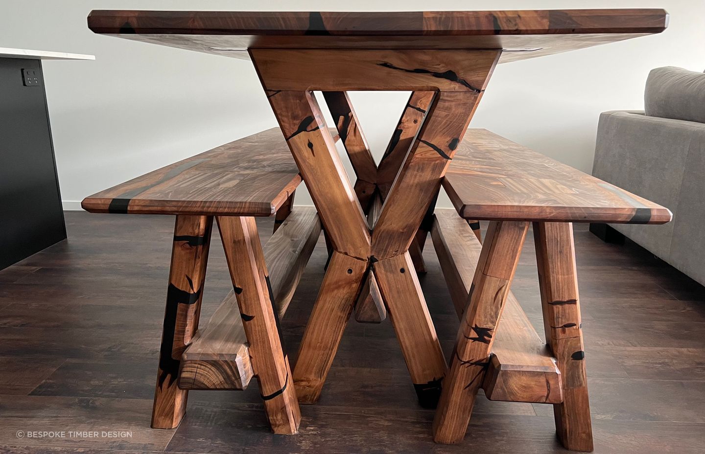Reclaimed macrocarpa timber from an old table has been used to create a new table and accompanying bench seats that encapsulate the unique character and history of the wood. Each imperfection in the timber has been transformed into a striking feature, accentuated by stunning black epoxy infills.