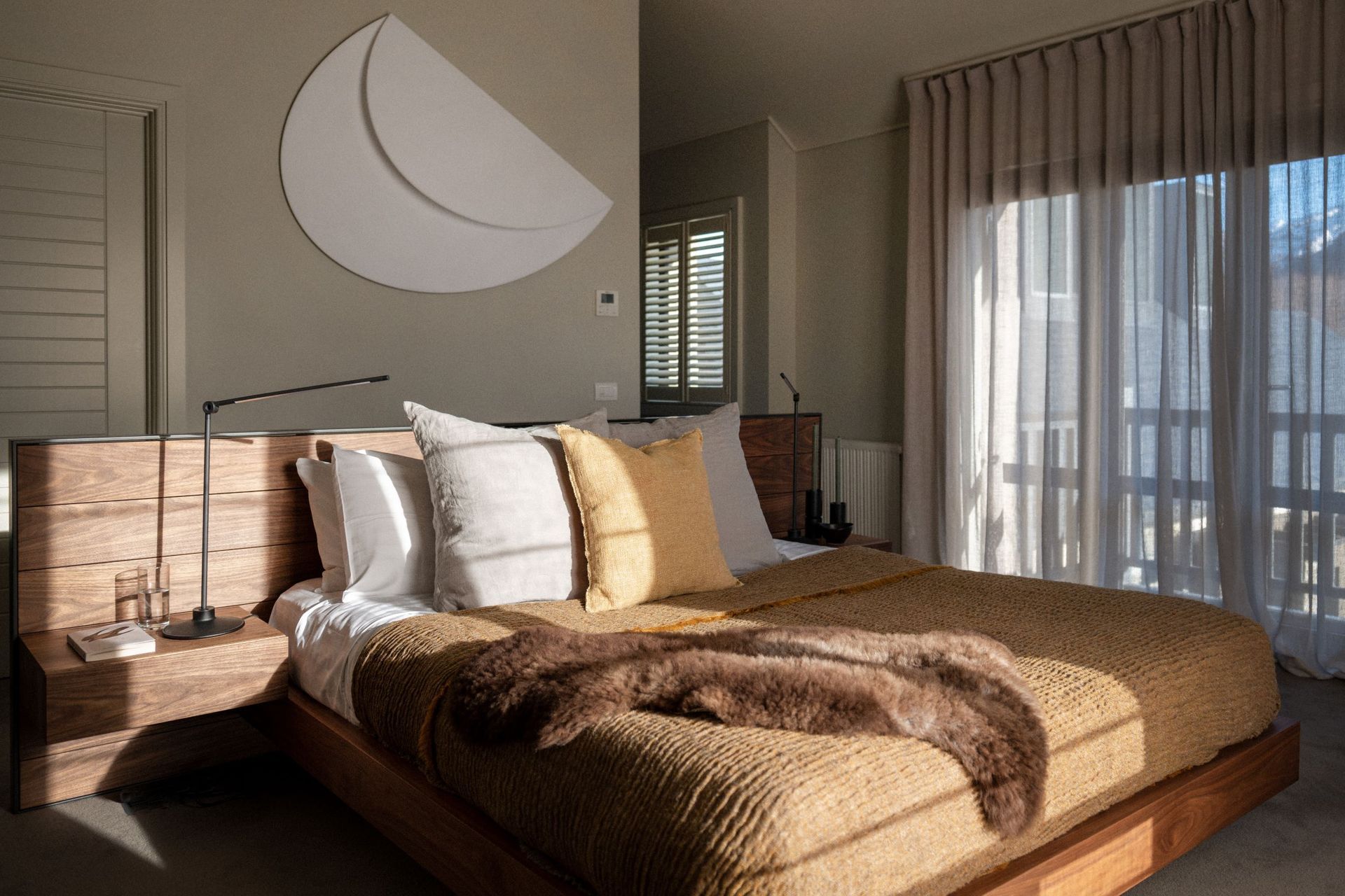 Combining textures, like the natural hardwood bed frame and soft bedding of this gorgeous South Island home, adds warmth and visual interest to a bedroom.
