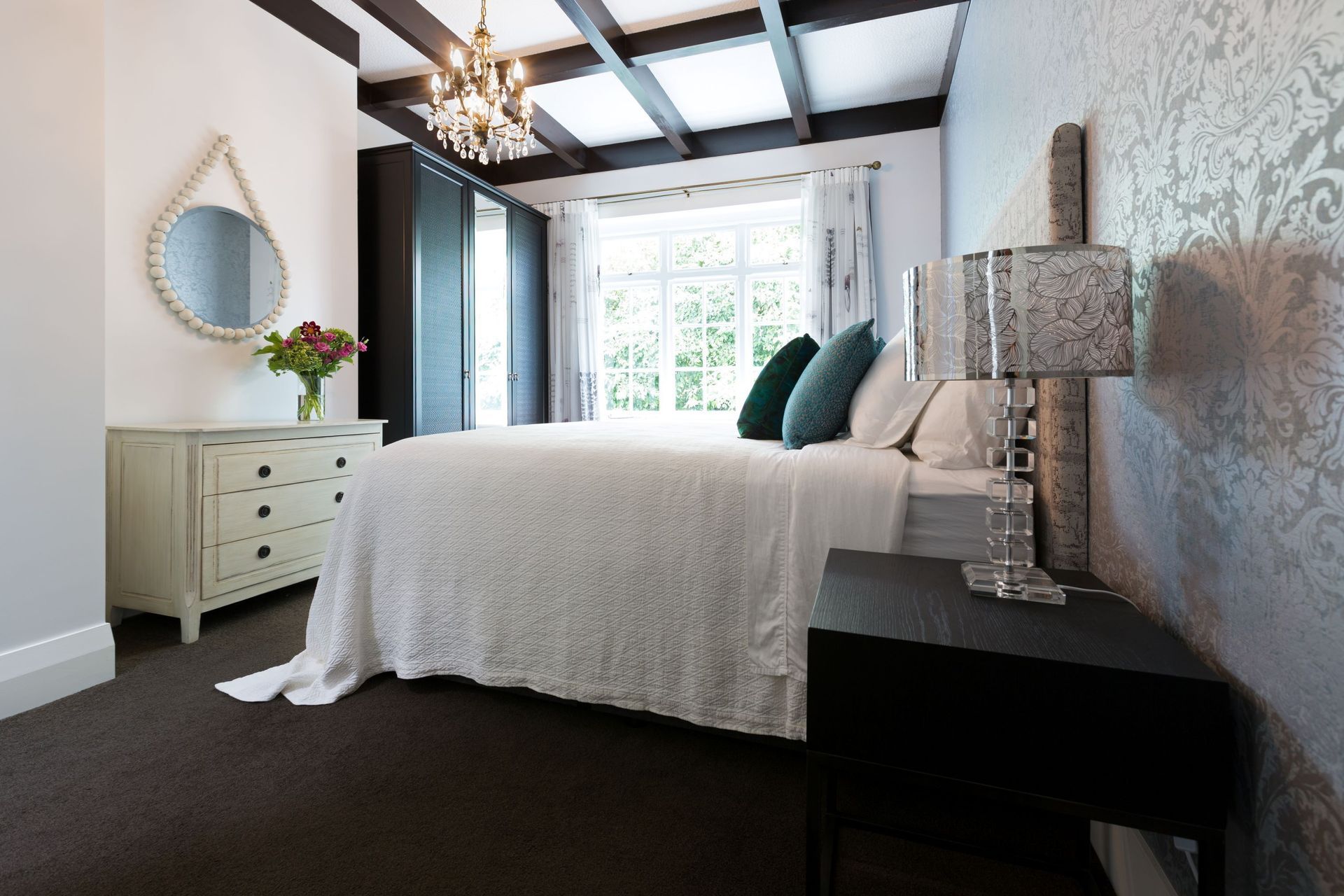 Warm toned bulbs, like those in the exquisite chandelier in this Pukenui Road residence, combine well with natural light to bring comfort to a space.