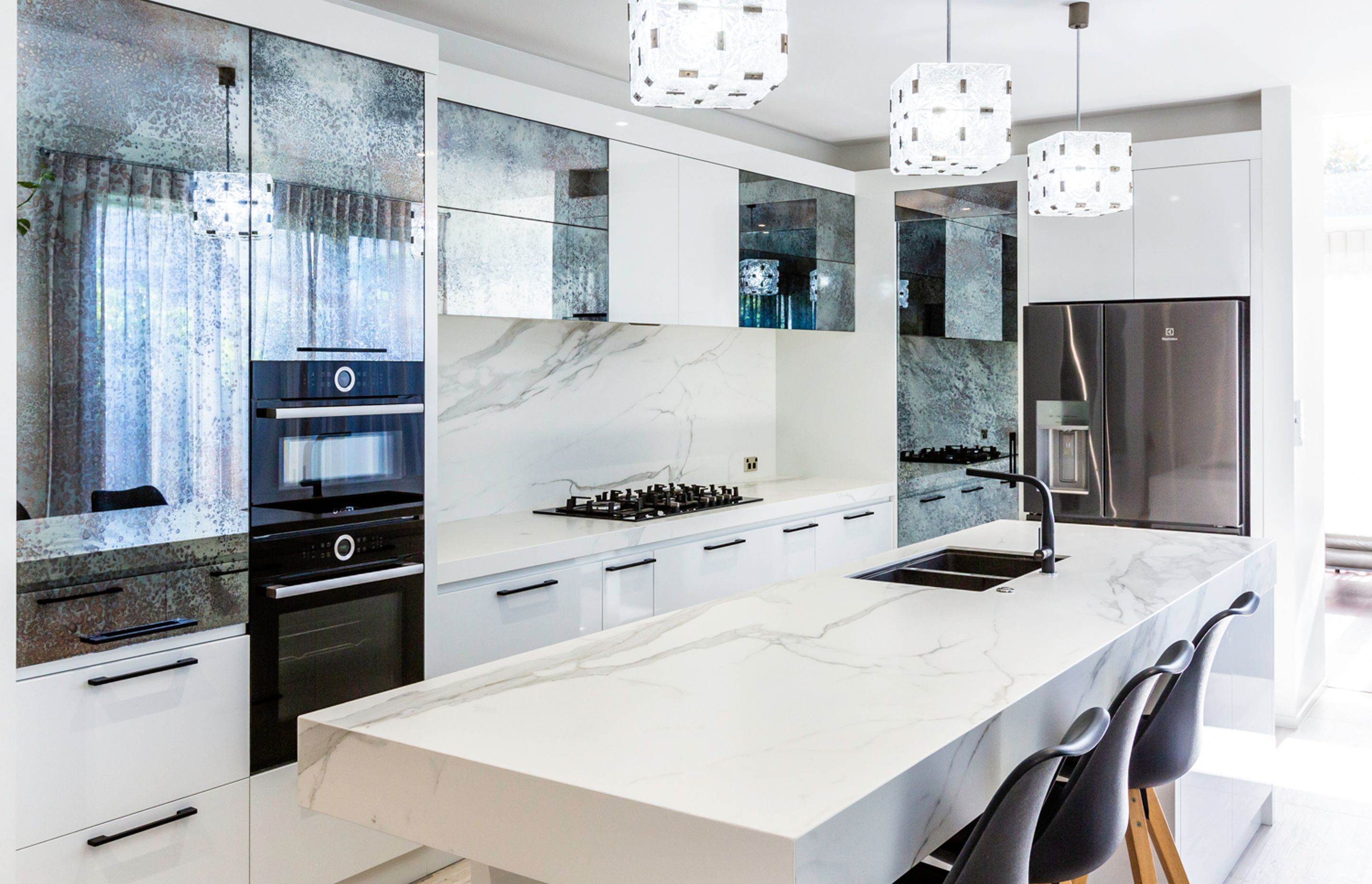 This kitchen demonstrates how versatile antique mirror is, working in easily  with a contemporary aesthetic.