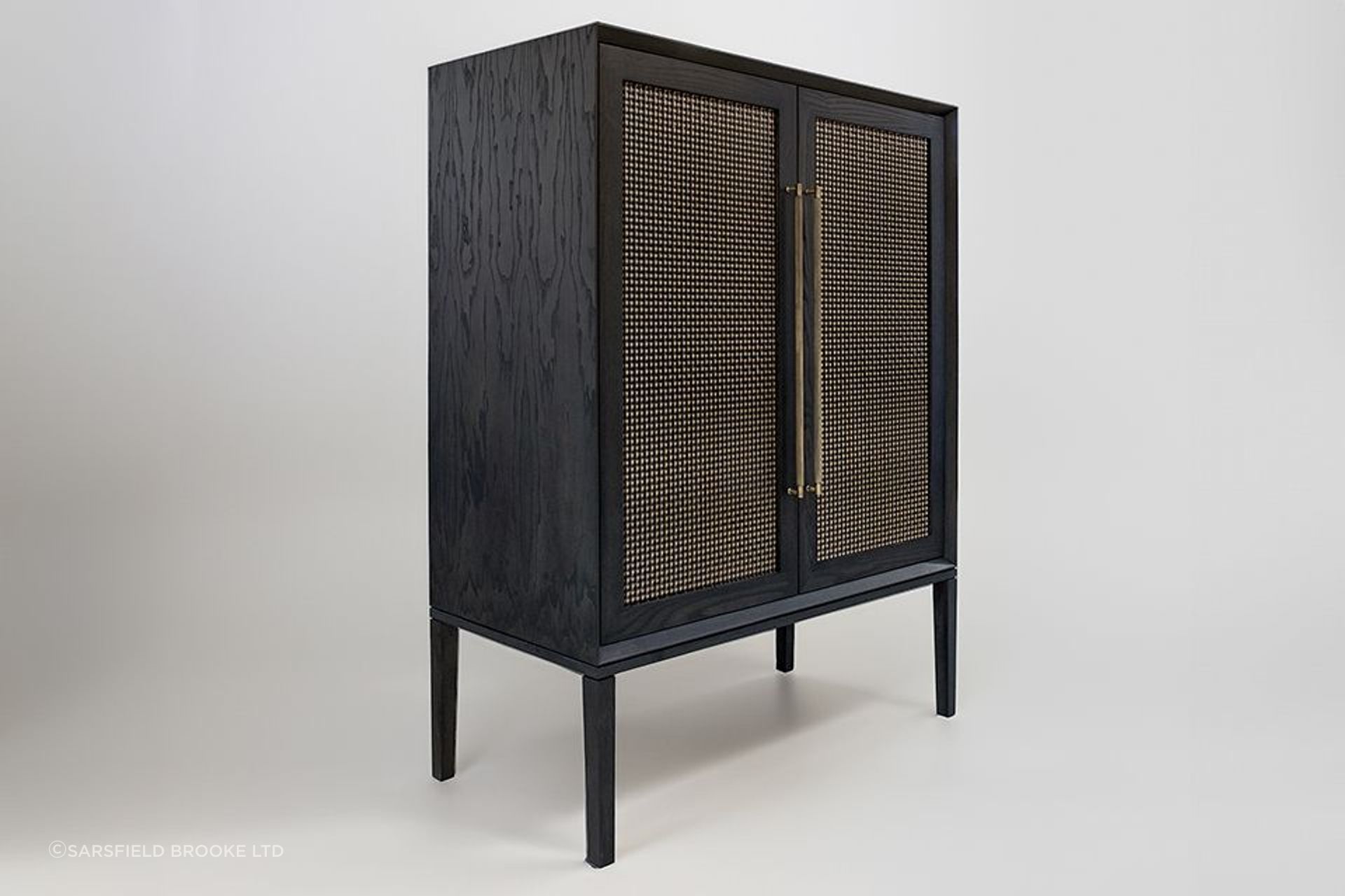 Sarsfield Brooke's new Wimberley bar cabinet design in American Ash initially came to life on CAD by the in-house designers. Boasting woven brass door panels, brass door handles, adjustable timber shelving and automated LED lighting.