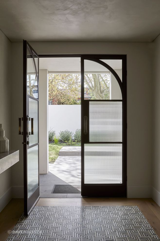 Square steel mullions were incorporated on the entry doors to complement the hallway archway.