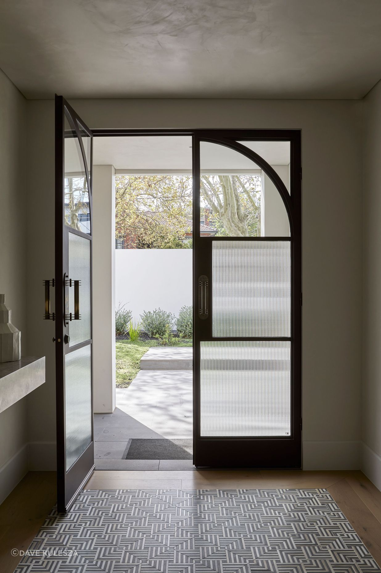 Square steel mullions were incorporated on the entry doors to complement the hallway archway.