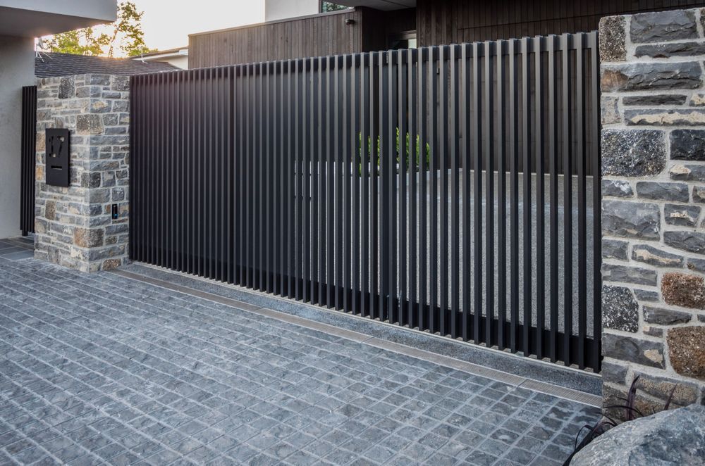 The sliding drive gate is automated and equipped with safety beams.