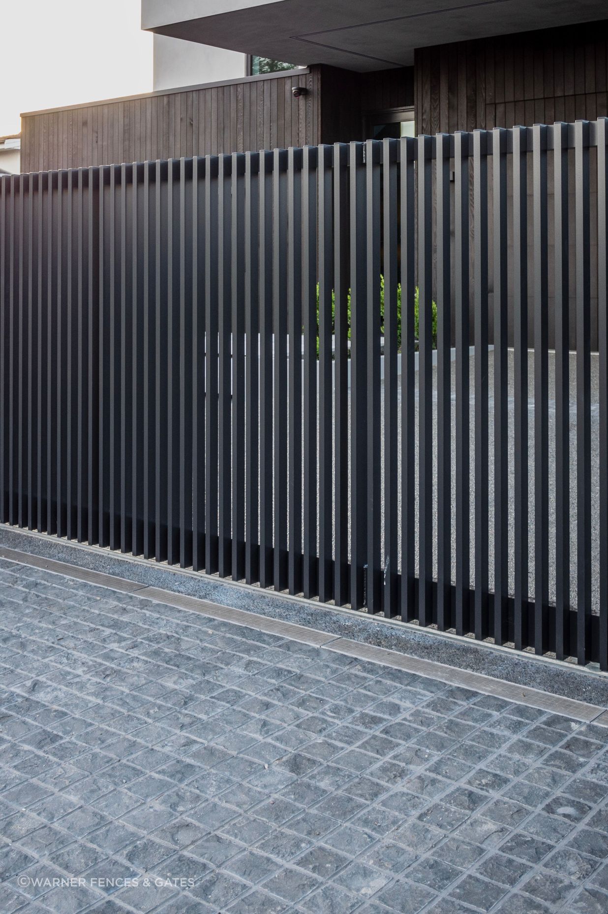The sliding drive gate is automated and equipped with safety beams.