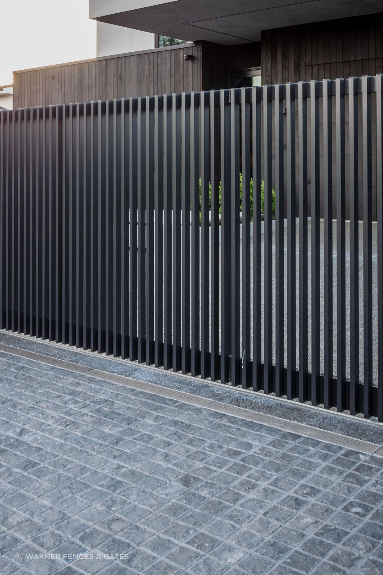 The sliding drive gate is automated and equipped with safety beams.
