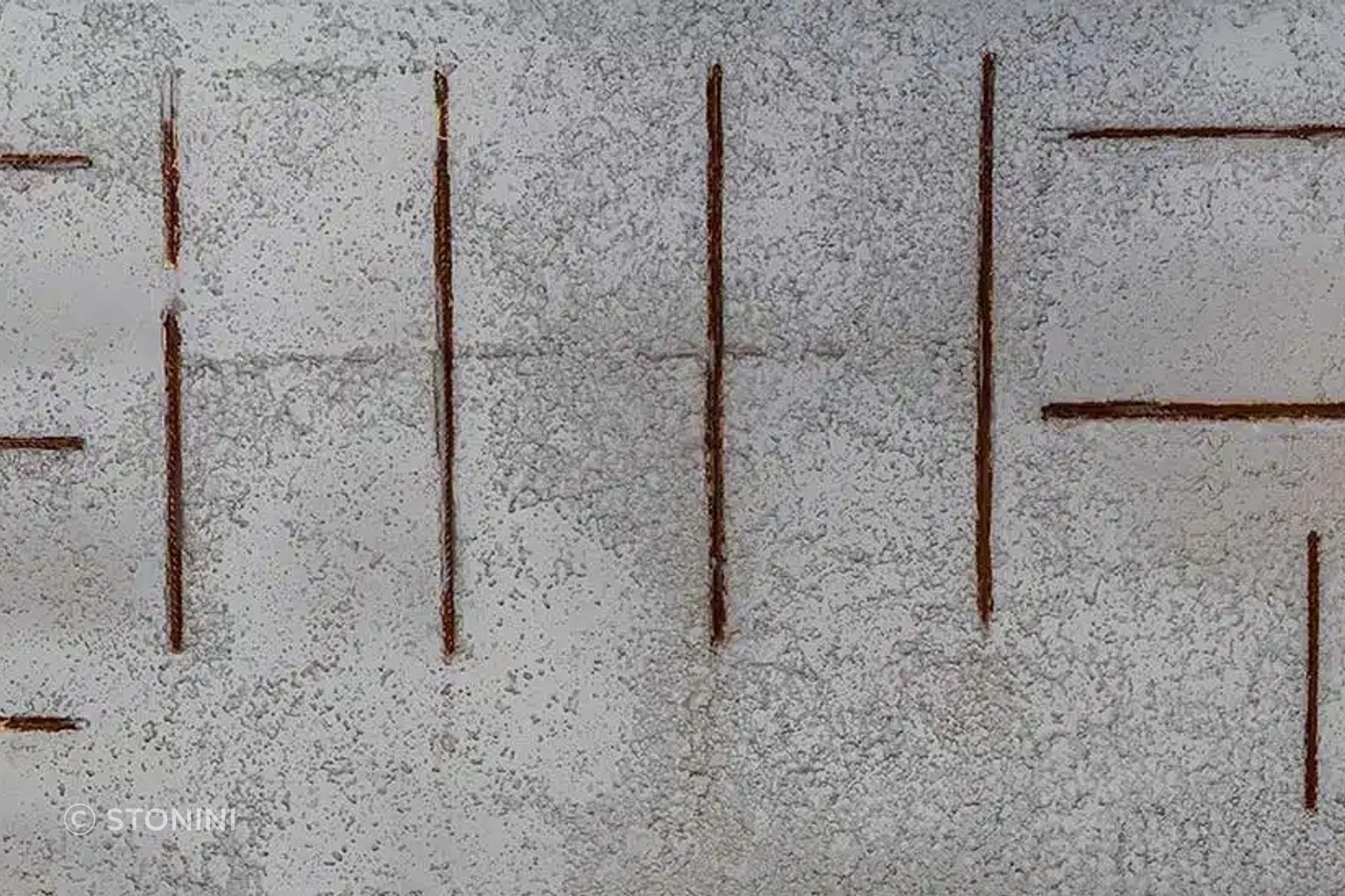 “Hormigon Picado Chico” concrete panel from Stonini emulates exposed aggregate concrete with rusted metal bars