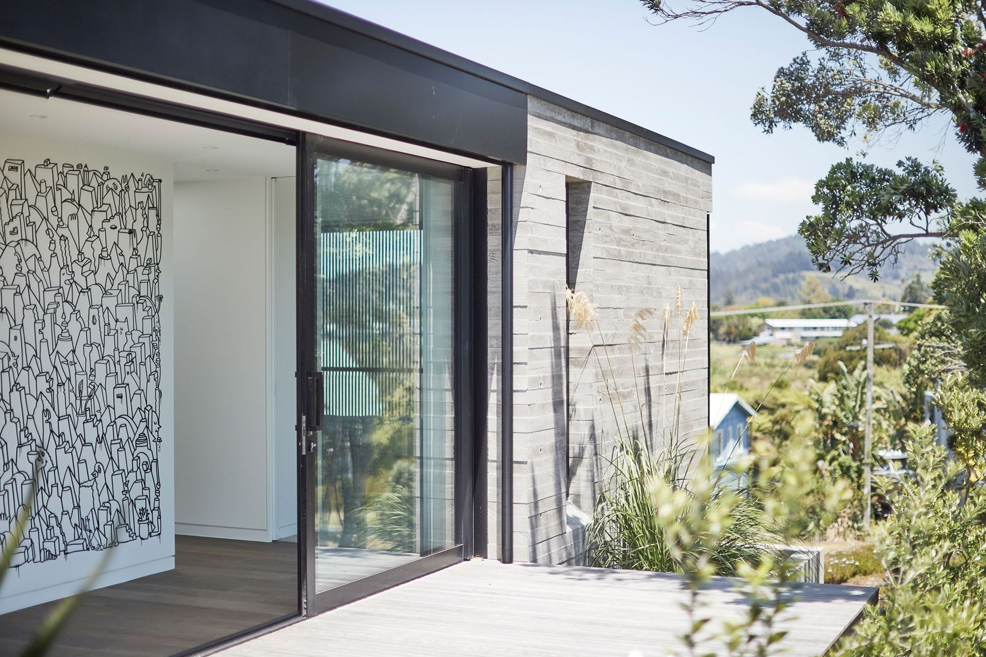 A large mural by artist Andrew J. Steel features inside the Tairua Insitu House by Neu Architecture.