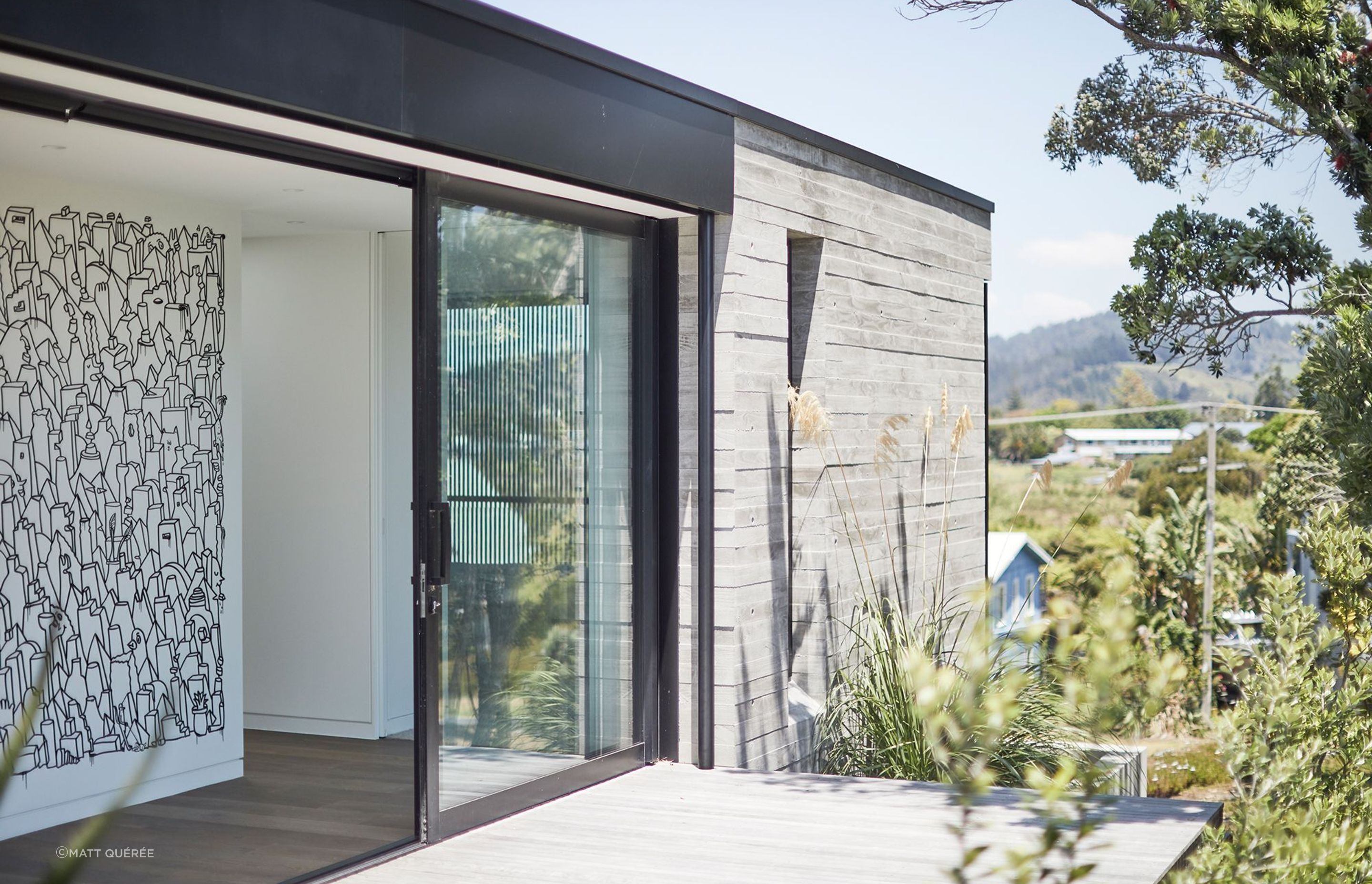 A large mural by artist Andrew J. Steel features inside the Tairua Insitu House by Neu Architecture.