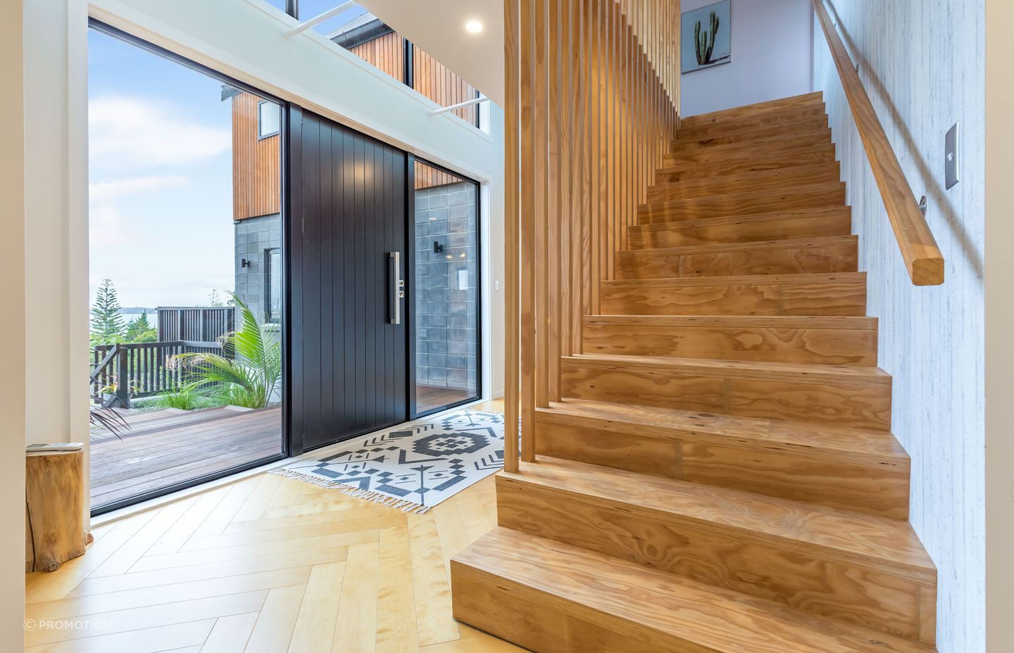 Tony designed and built the stairs himself and it was deceptively simple. Concrete-look wallpaper in the entrance continues the home’s textural theme.