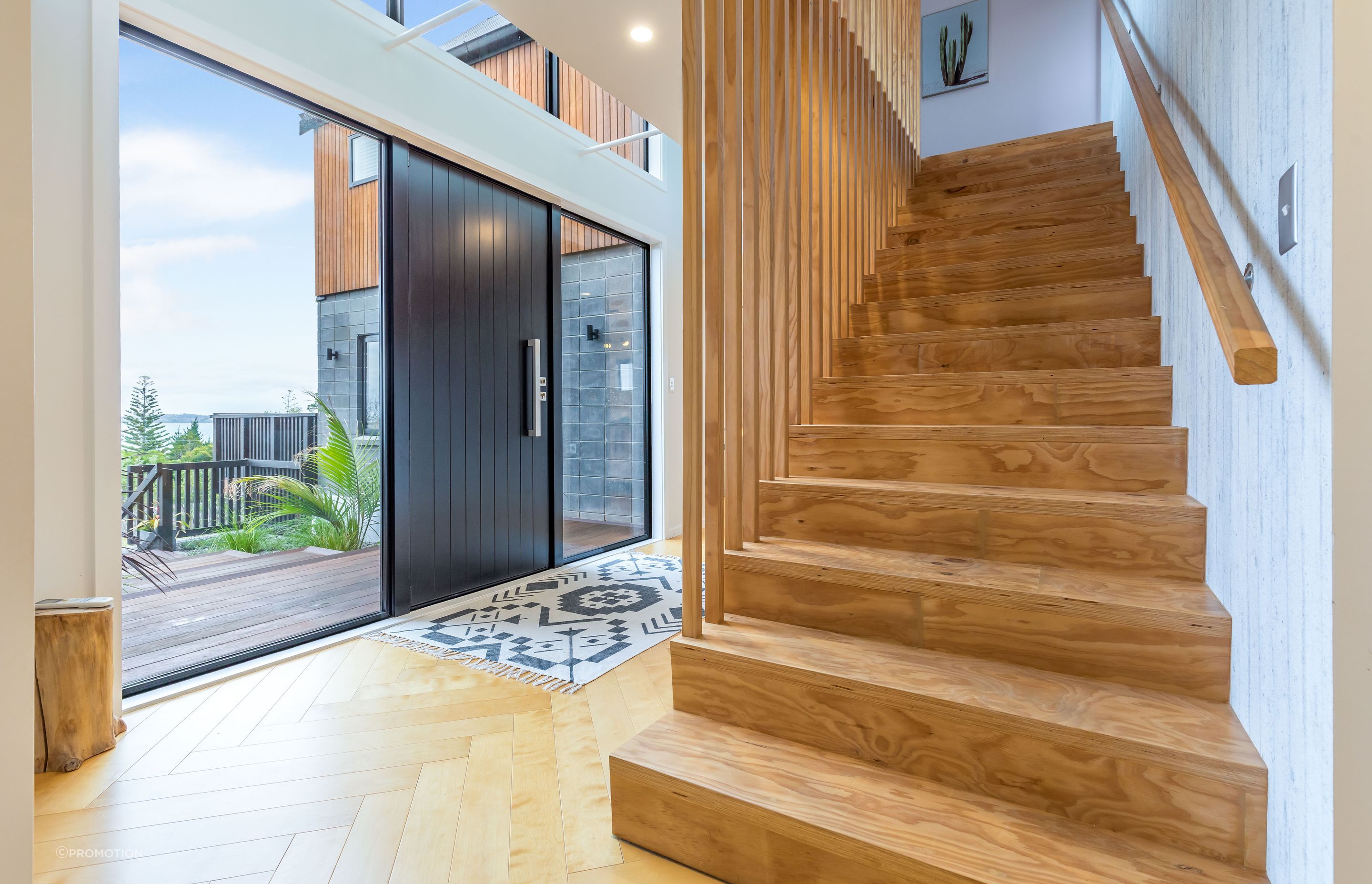 Tony designed and built the stairs himself and it was deceptively simple. Concrete-look wallpaper in the entrance continues the home’s textural theme.