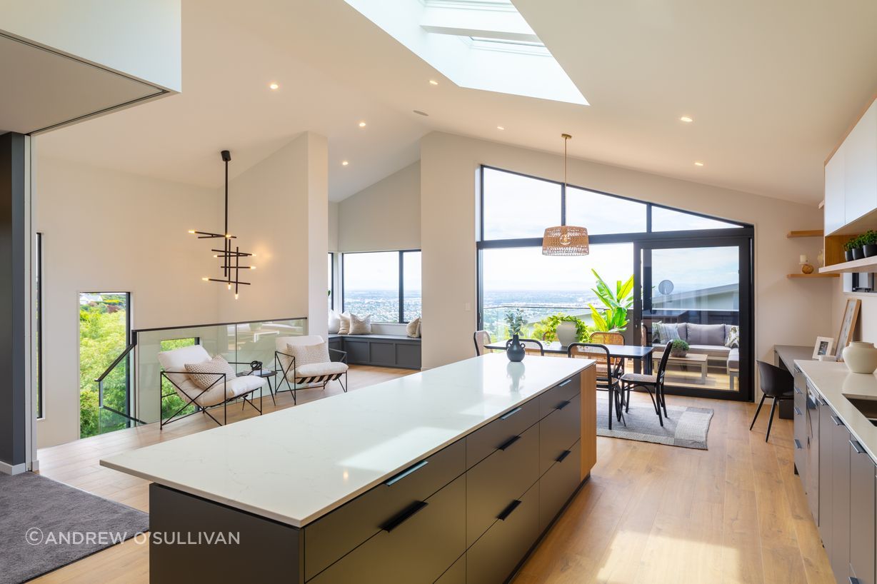 The stunning benchtop with waterfall end in this kitchen are engineered stone from Handcraft Kitchens and Joinery - colour is Cielo. The kitchen units are a mixture of Prime Melamine Anthracite, Melteca Snowdrift and Melteca Sublime Teak, with cabinetry pull handles.