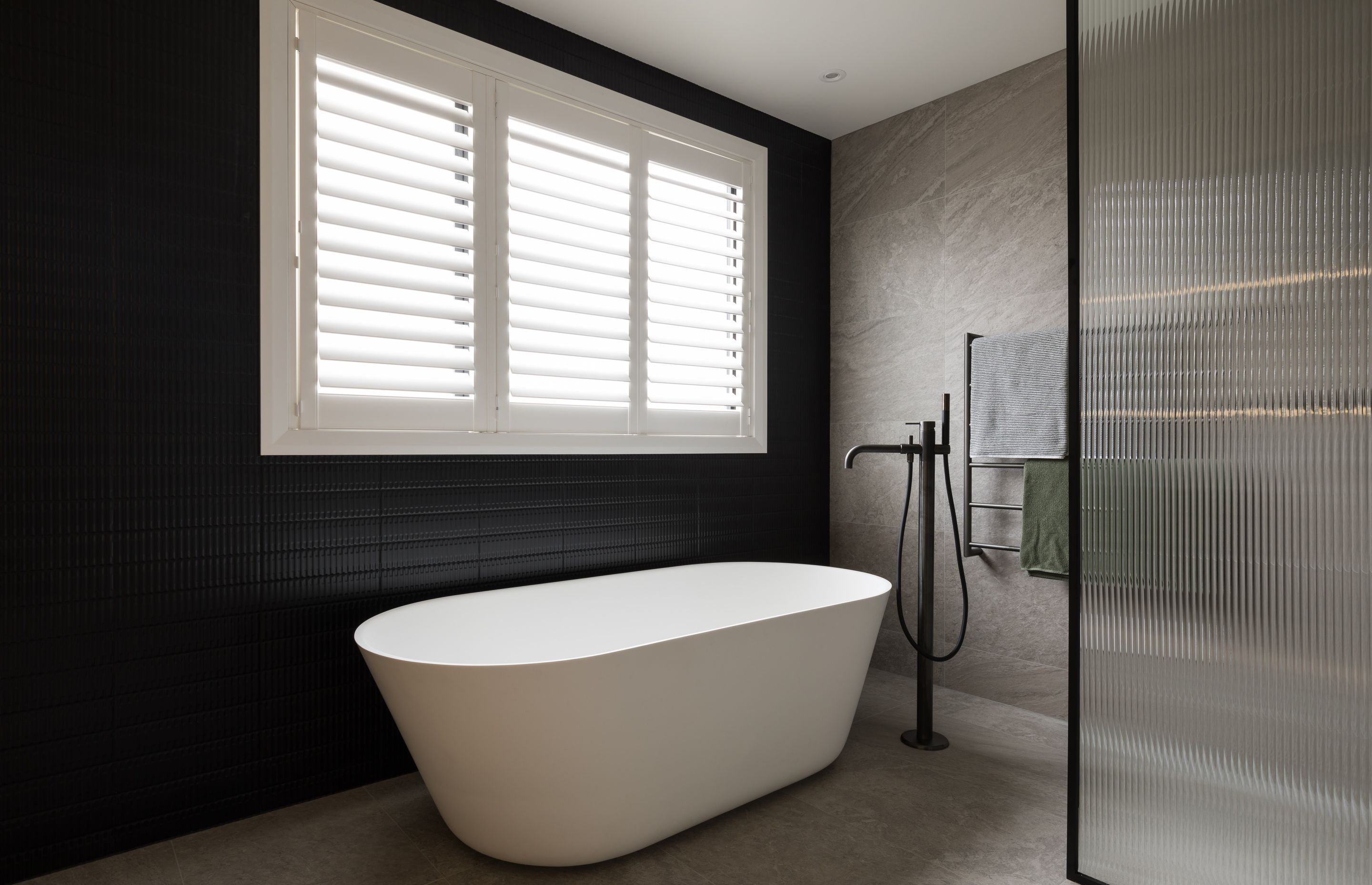 This bathroom by NM Design showcases reeded glass on the shower screen, which provides a good level of privacy without being a completely opaque material.