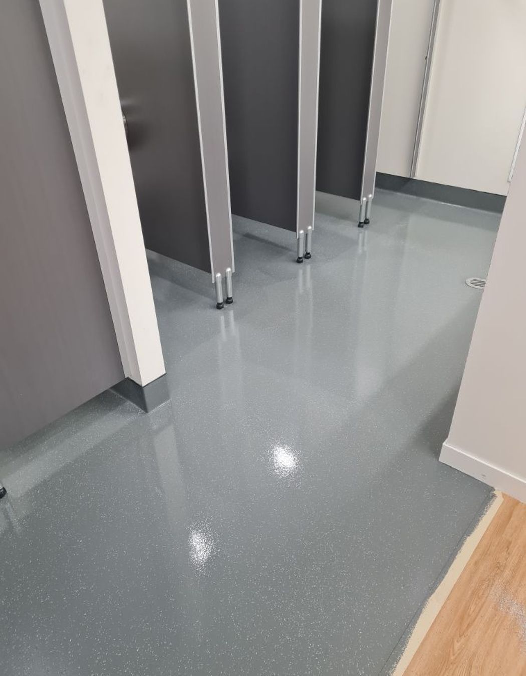 This image and below: Bona Resilient refreshes a toilet space, and flakes added in create a classic commercial vinyl look.