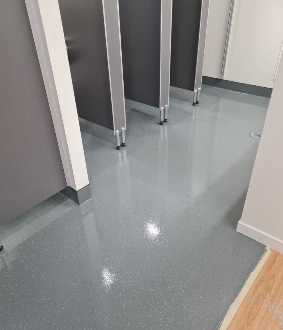 This image and below: Bona Resilient refreshes a toilet space, and flakes added in create a classic commercial vinyl look.