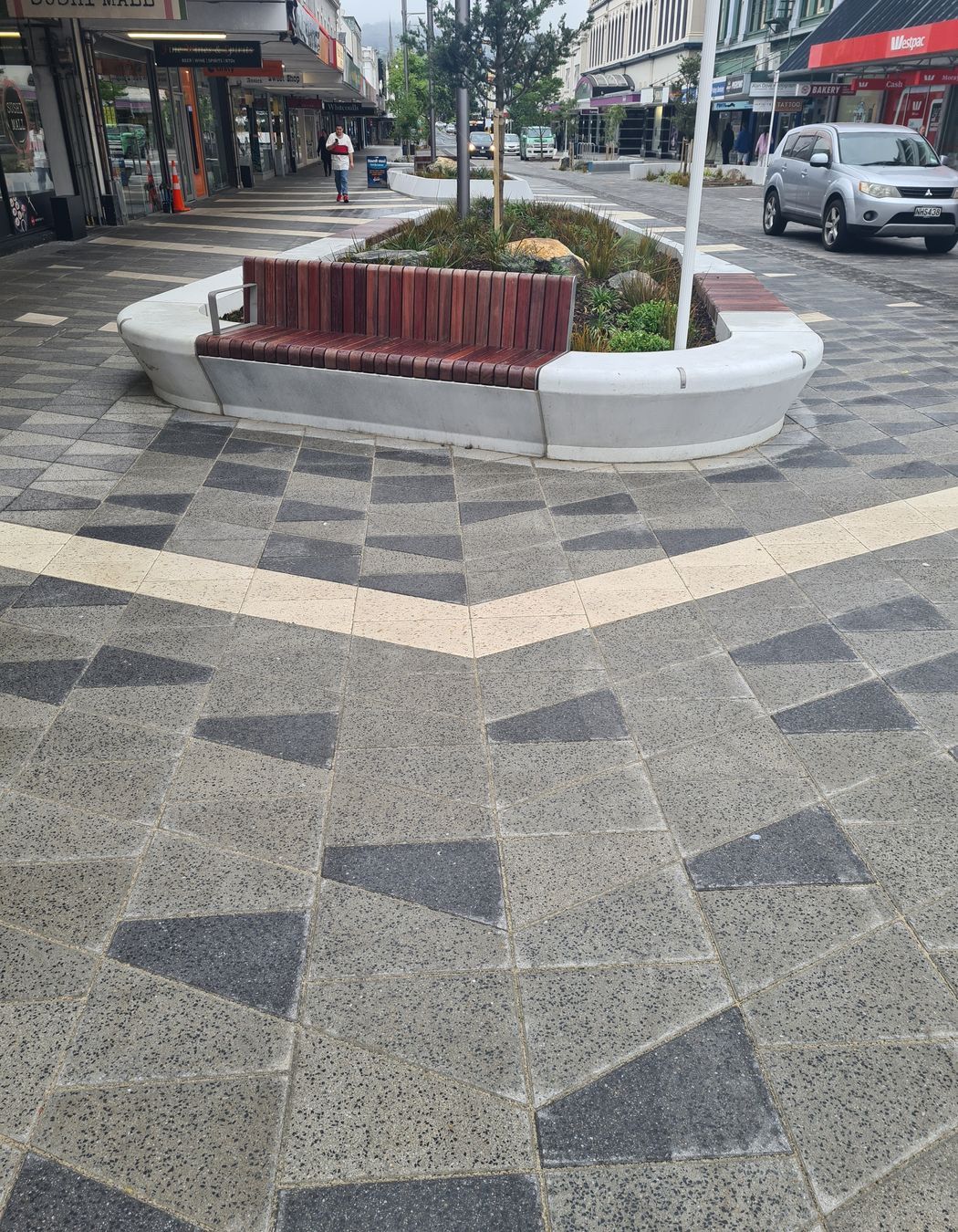 The streetscape offers places to sit and enjoy the paving patterns and through them learn more about the area's history.