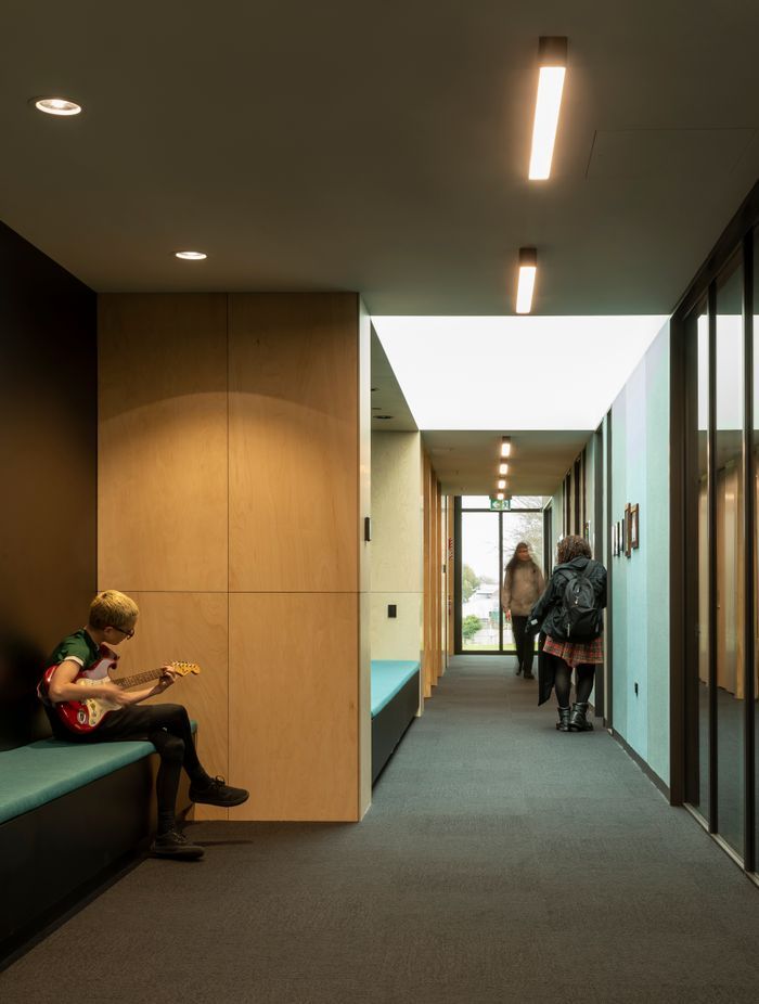 The acoustic wall panels in the multipurpose hall are teal, helping students and visitors with navigation.