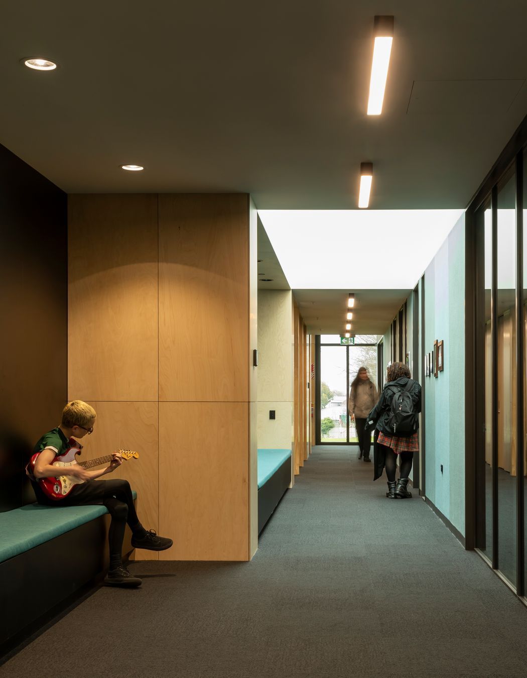 The acoustic wall panels in the multipurpose hall are teal, helping students and visitors with navigation.