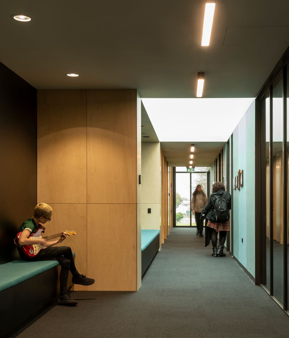The acoustic wall panels in the multipurpose hall are teal, helping students and visitors with navigation.