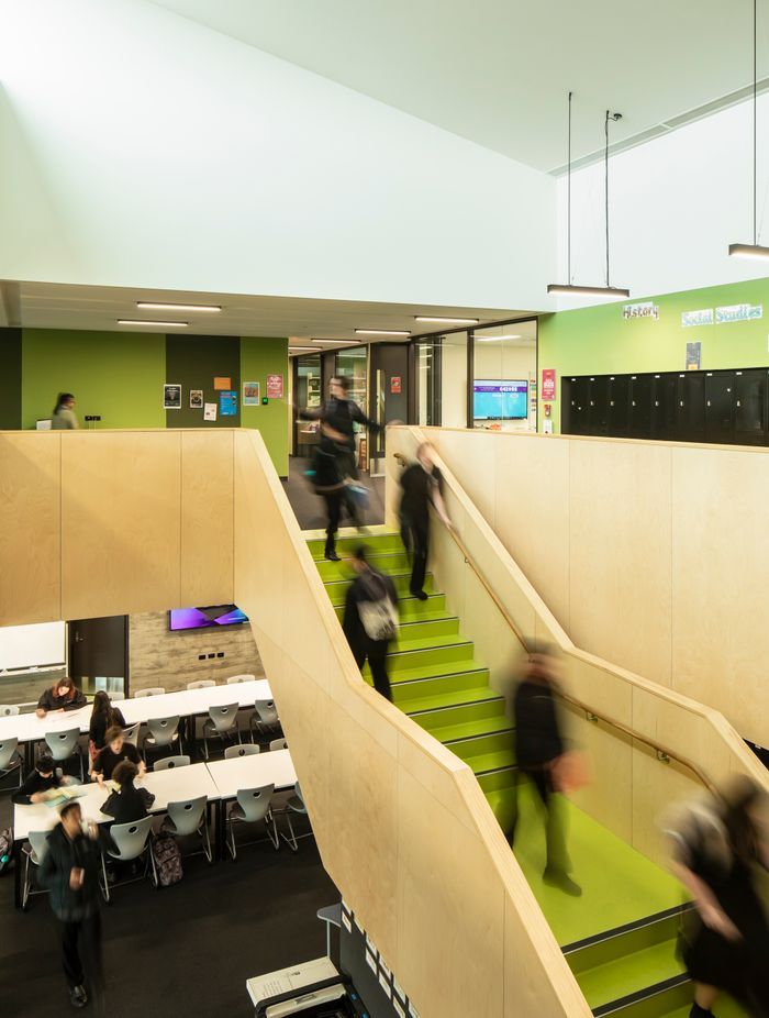 The learning hub features green wall panels and stairs.
