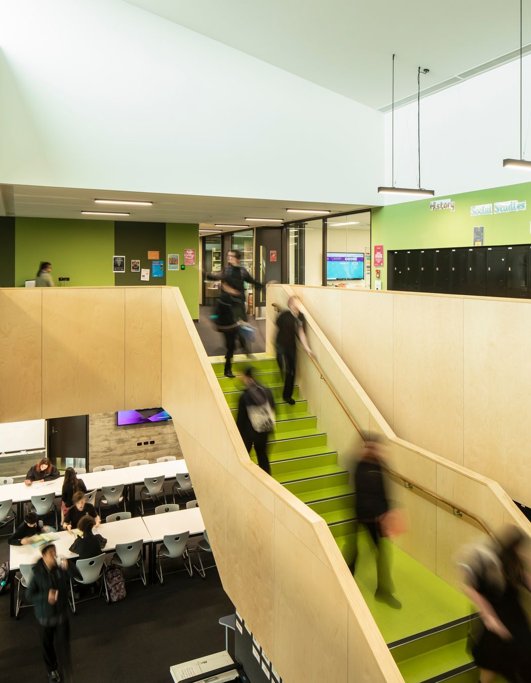 The learning hub features green wall panels and stairs.