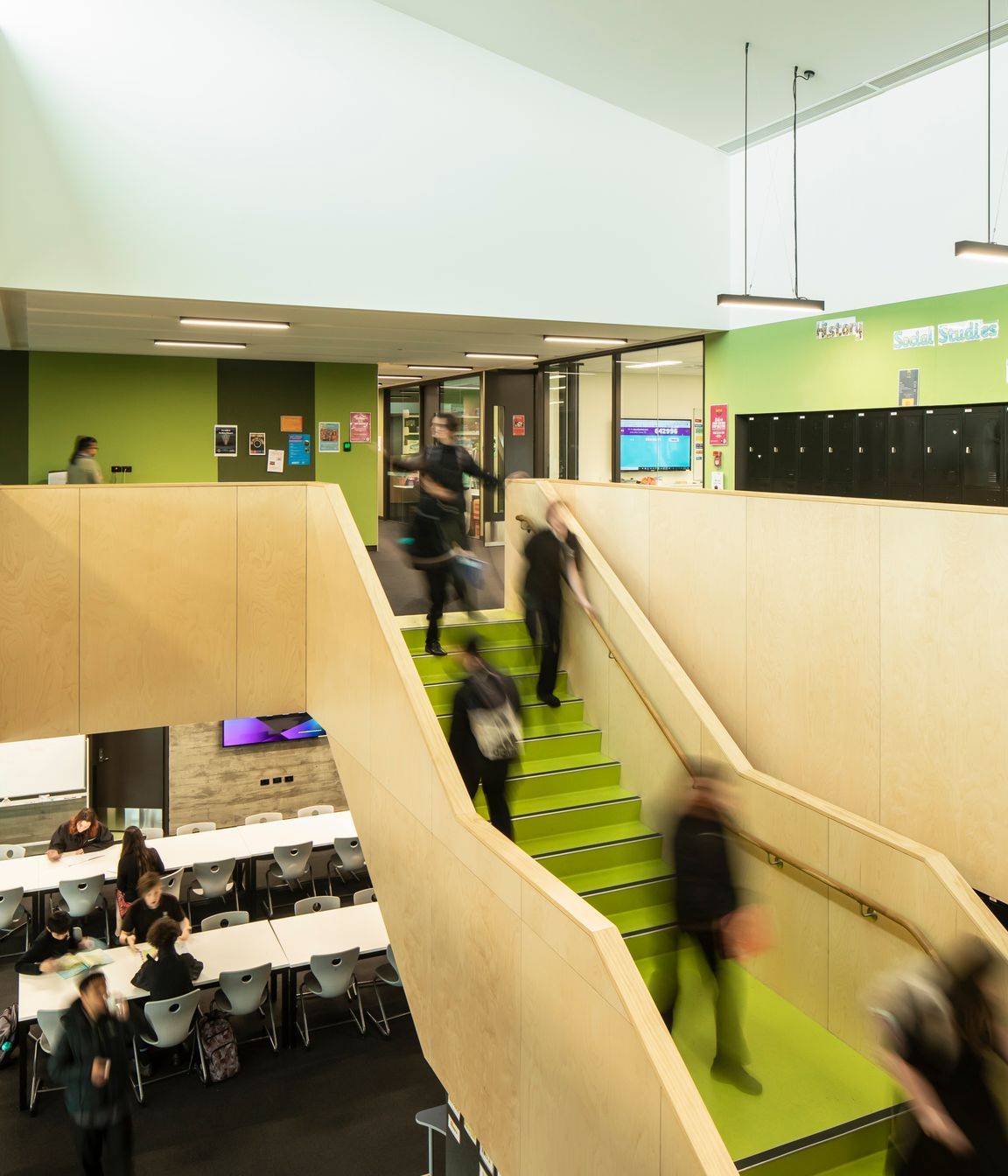 The learning hub features green wall panels and stairs.