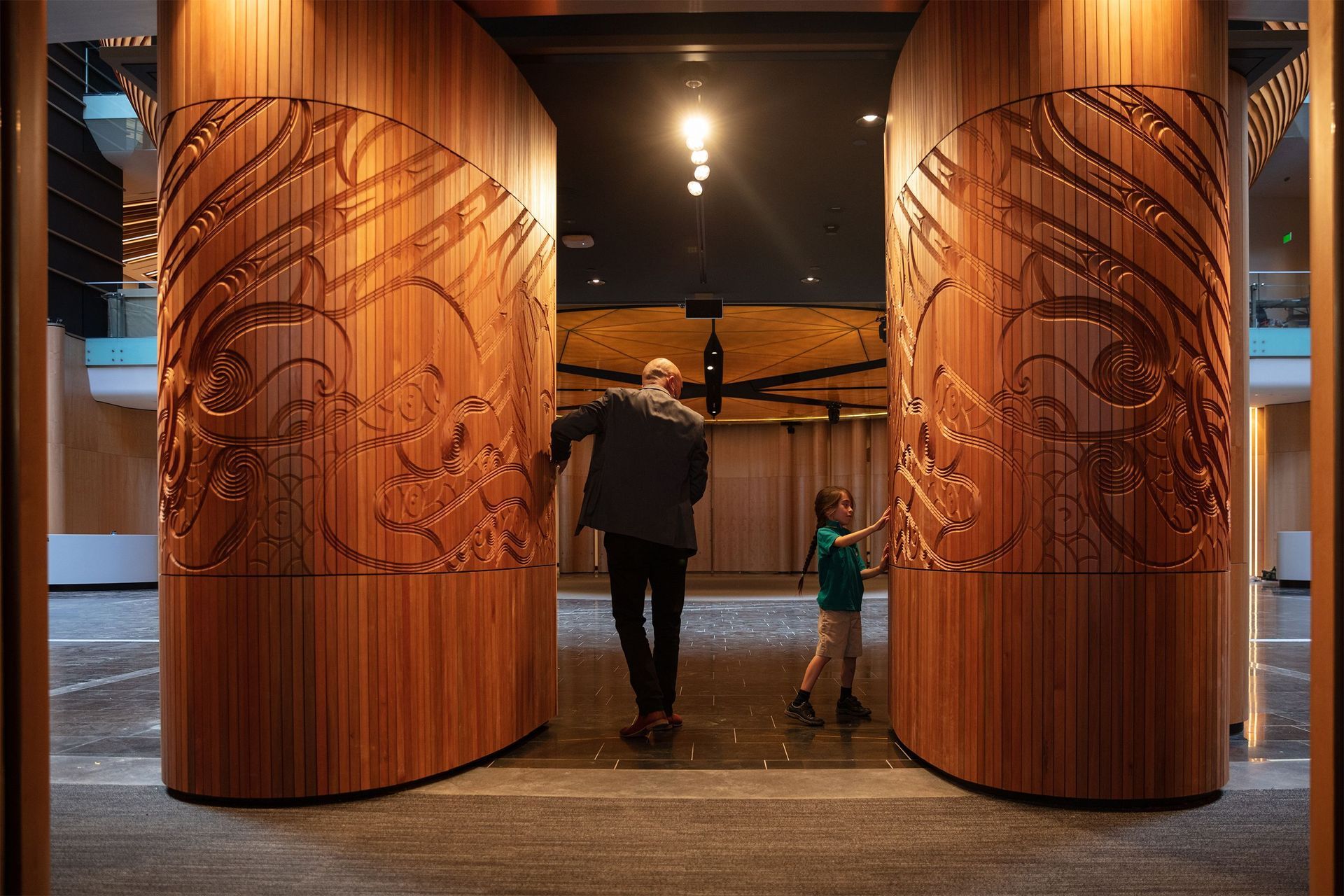 Te Tatau Kaitiaki by Ngāti Whātua artist Graham Tipene—made of CNC-routed timber—depicts two female faces and greets visitors entering through the southern entrance of the South Atrium.