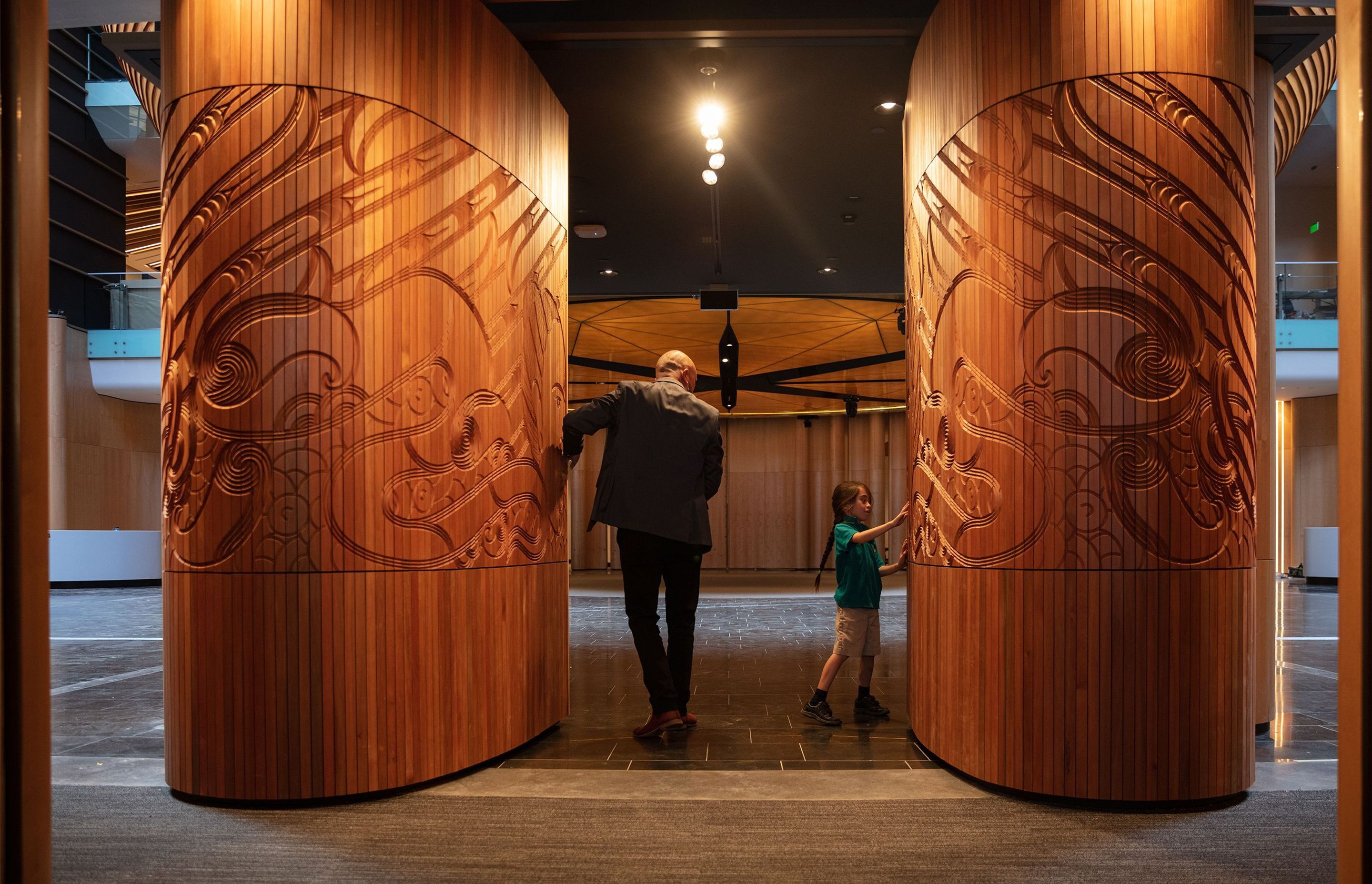 Te Tatau Kaitiaki by Ngāti Whātua artist Graham Tipene—made of CNC-routed timber—depicts two female faces and greets visitors entering through the southern entrance of the South Atrium.