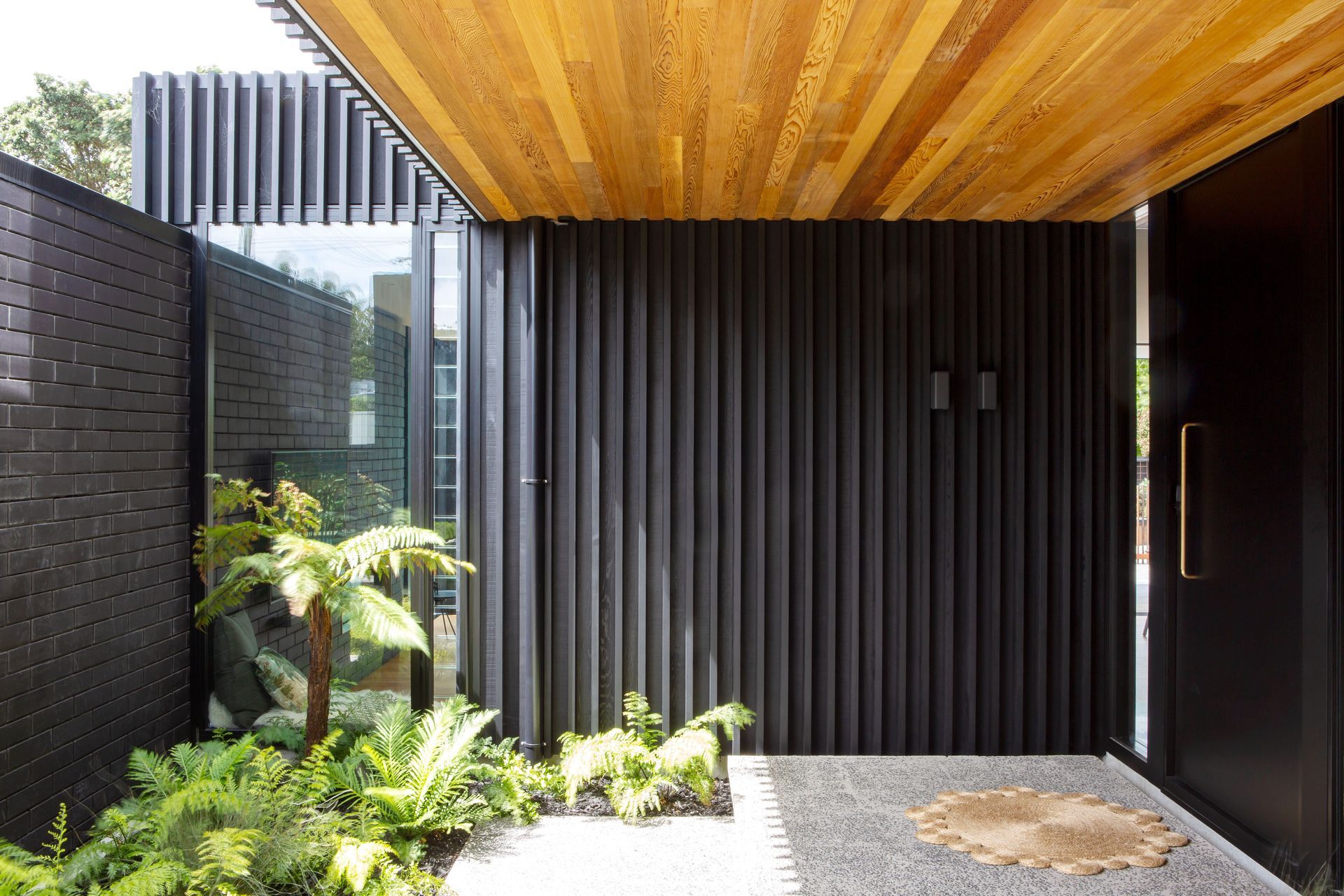 The front door, reached after walking through layers of gardens to ensure privacy. “It allows us to use that outdoor space as part of the entry,” says Tim. Dorrington Atcheson Architects worked with Strachan Group Landscape Architects on the landscaping.