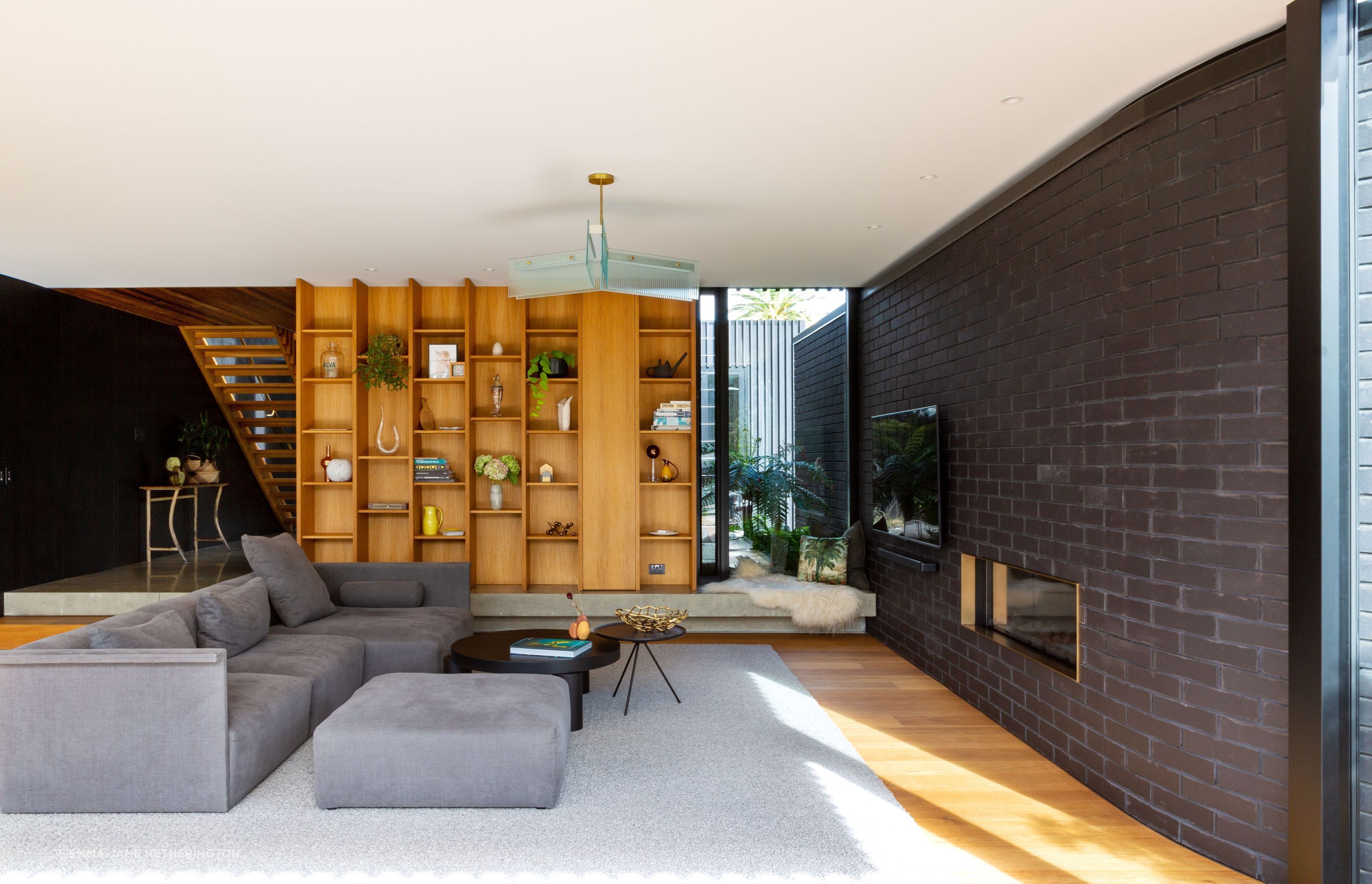 The concrete floor of the foyer steps down into the living room, to increase the room height, and the negative detail underneath has LED lighting. The cosy corner looks out to the entry courtyard. “With underfloor heating, it's slightly warm,” says Rina. 