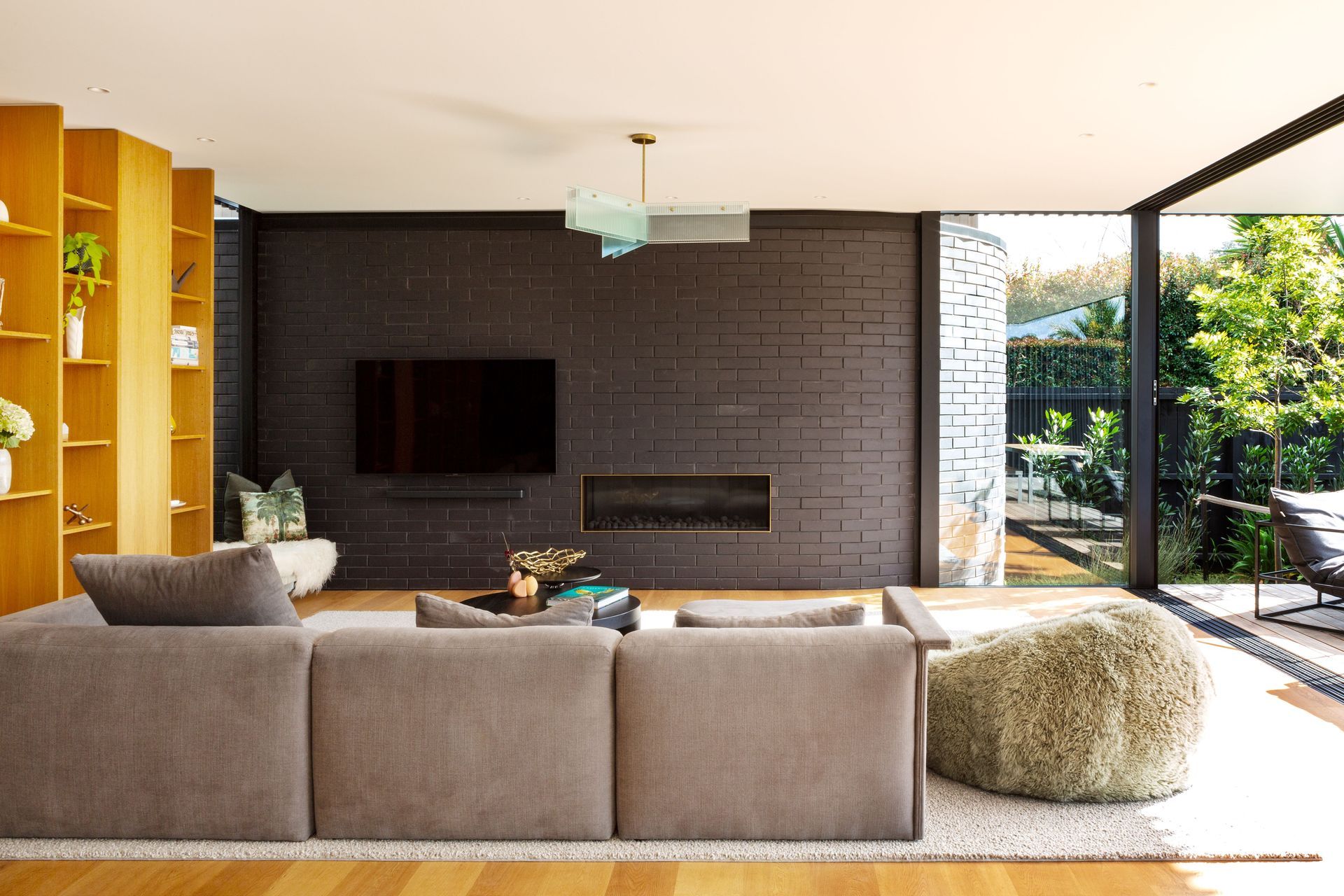 “This is the side wall of the house almost peeling out. It’s like kinetic movement: the idea that the house has opened itself up to the view,” says Tim. The insert around the Escea fireplace was made by Powersurge. The couch is from Simon James.