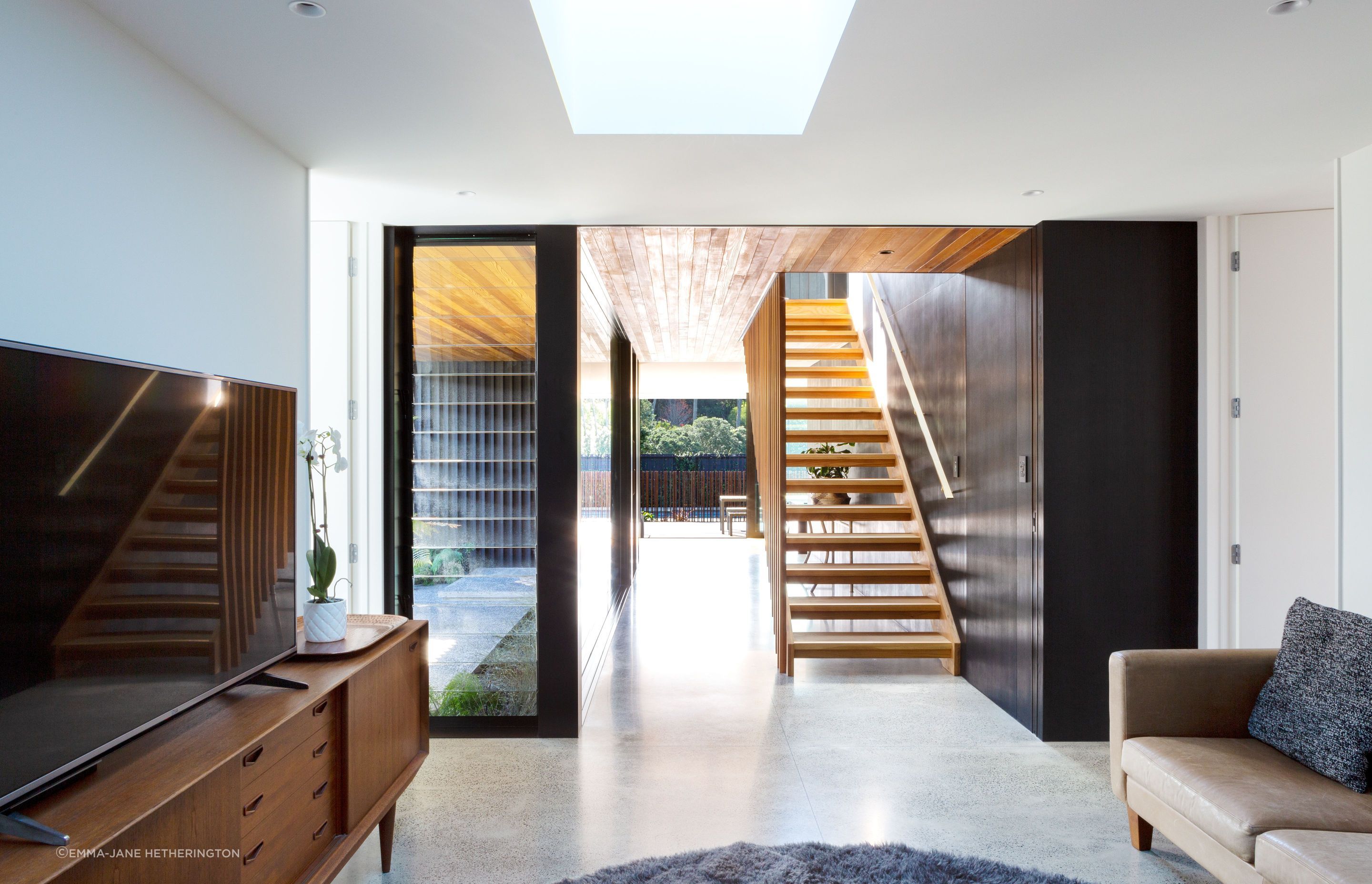 The view from the teenagers’ lounge through the entry foyer and out through the backyard. The change in ceiling material adds to the feeling of separation in the open space, says Tim.