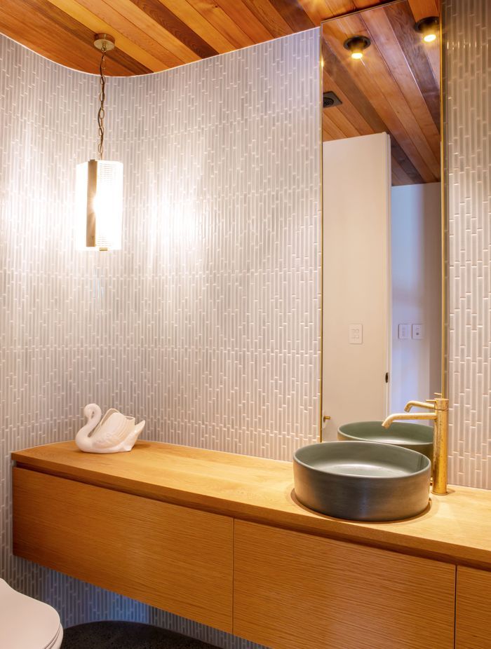 The powder room hidden in the foyer, echoing the curved motif outside the house.