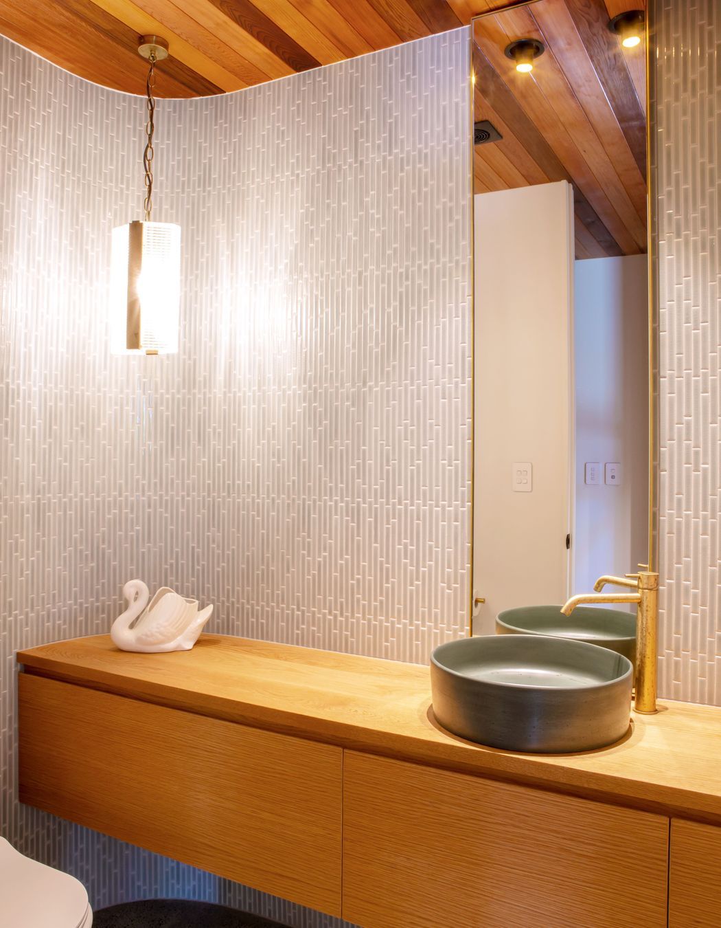 The powder room hidden in the foyer, echoing the curved motif outside the house.