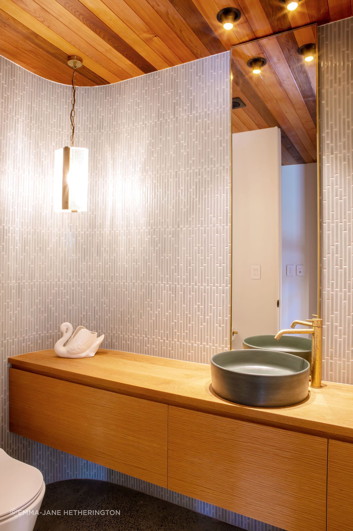 The powder room hidden in the foyer, echoing the curved motif outside the house.