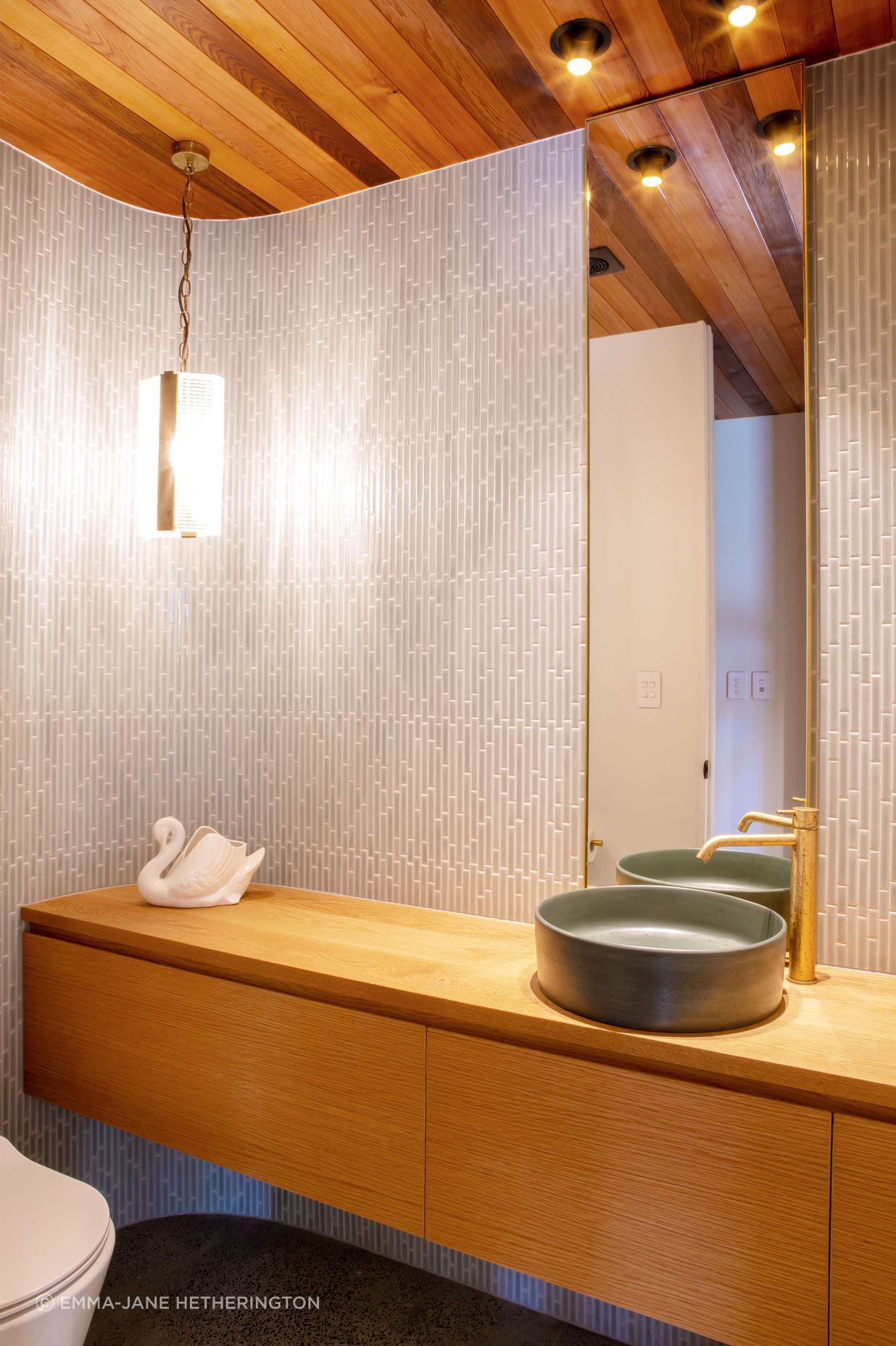 The powder room hidden in the foyer, echoing the curved motif outside the house.