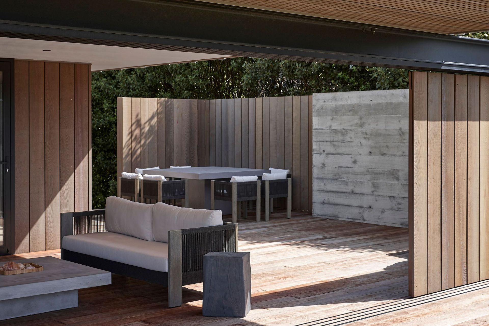 To the rear of the house, a second covered outdoor living space provides ample room for the extended family to spread out. Cedar softens the floors and walls here, integrating it into the environment.