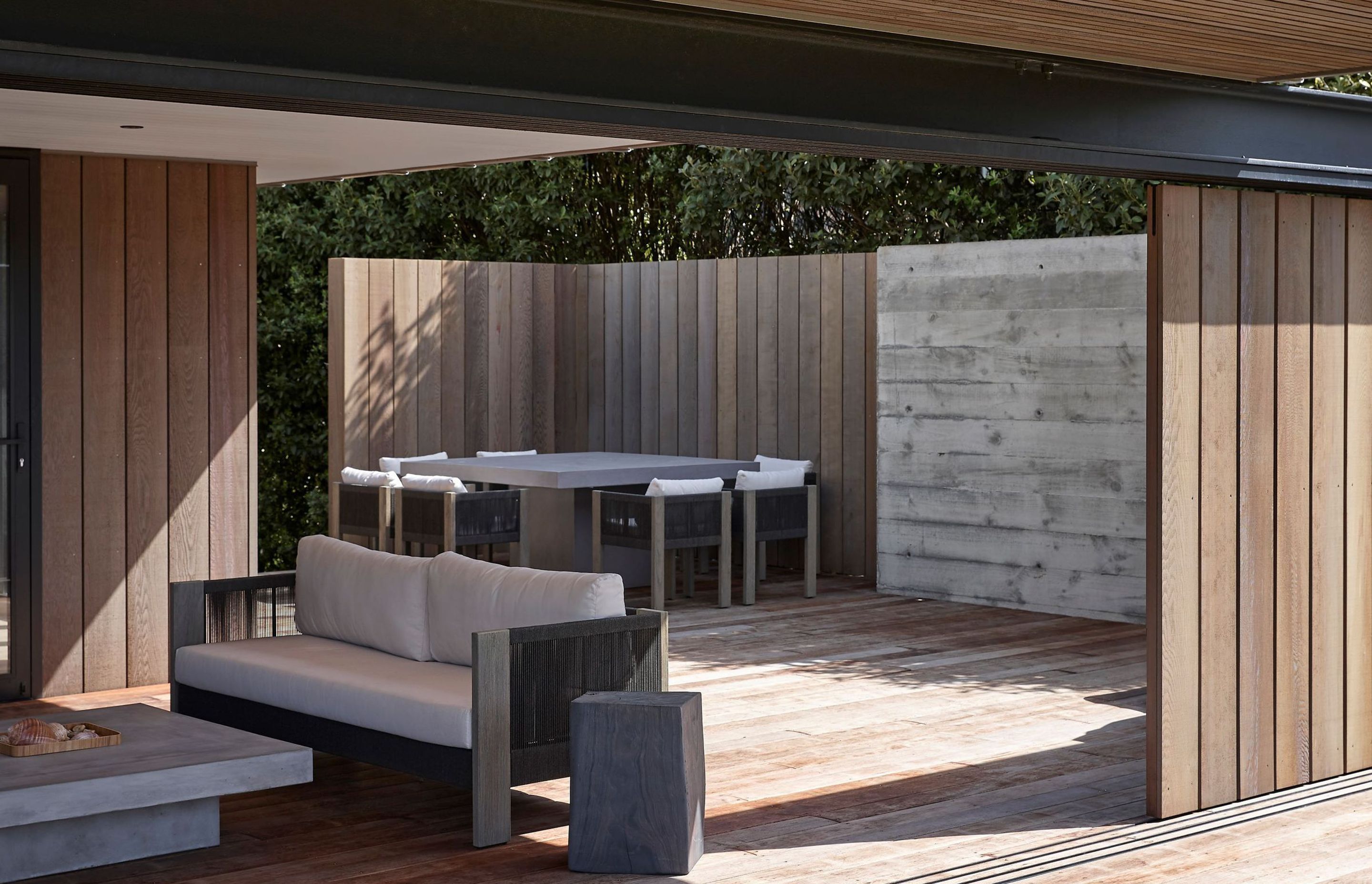 To the rear of the house, a second covered outdoor living space provides ample room for the extended family to spread out. Cedar softens the floors and walls here, integrating it into the environment.