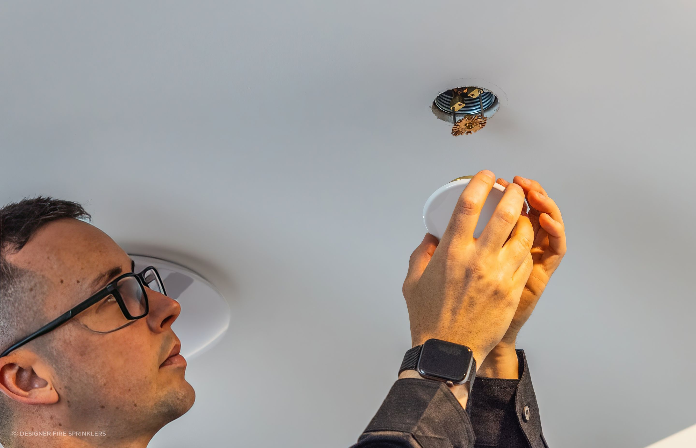 Designer Fire Sprinklers’ co-founder, Raphael Corbett installing a sprinkler head.