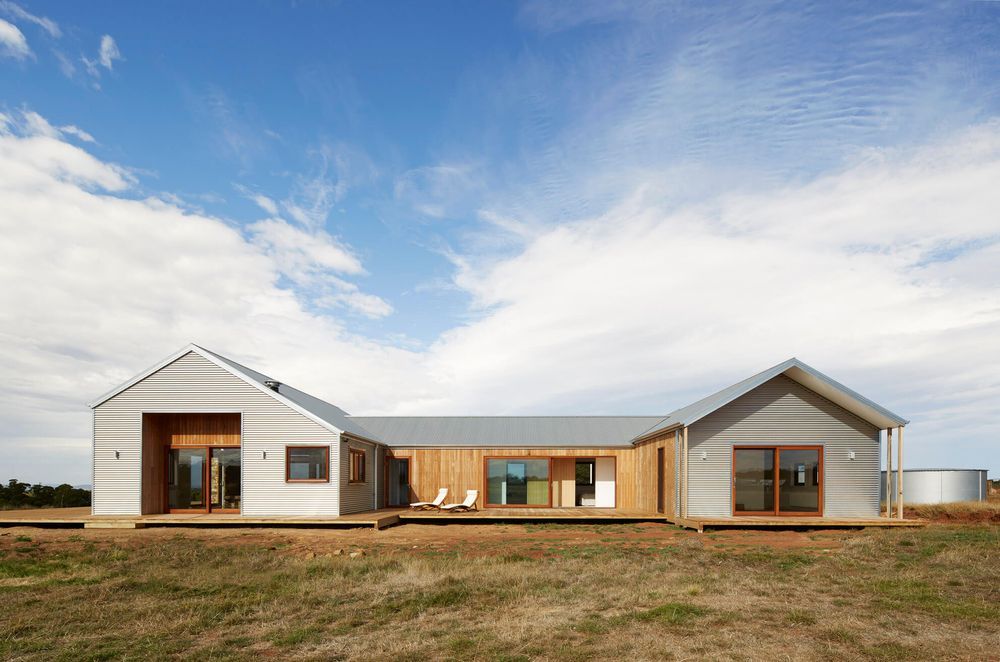 The pitched roof is designed for effective water collection into the tank, supporting sustainable living.