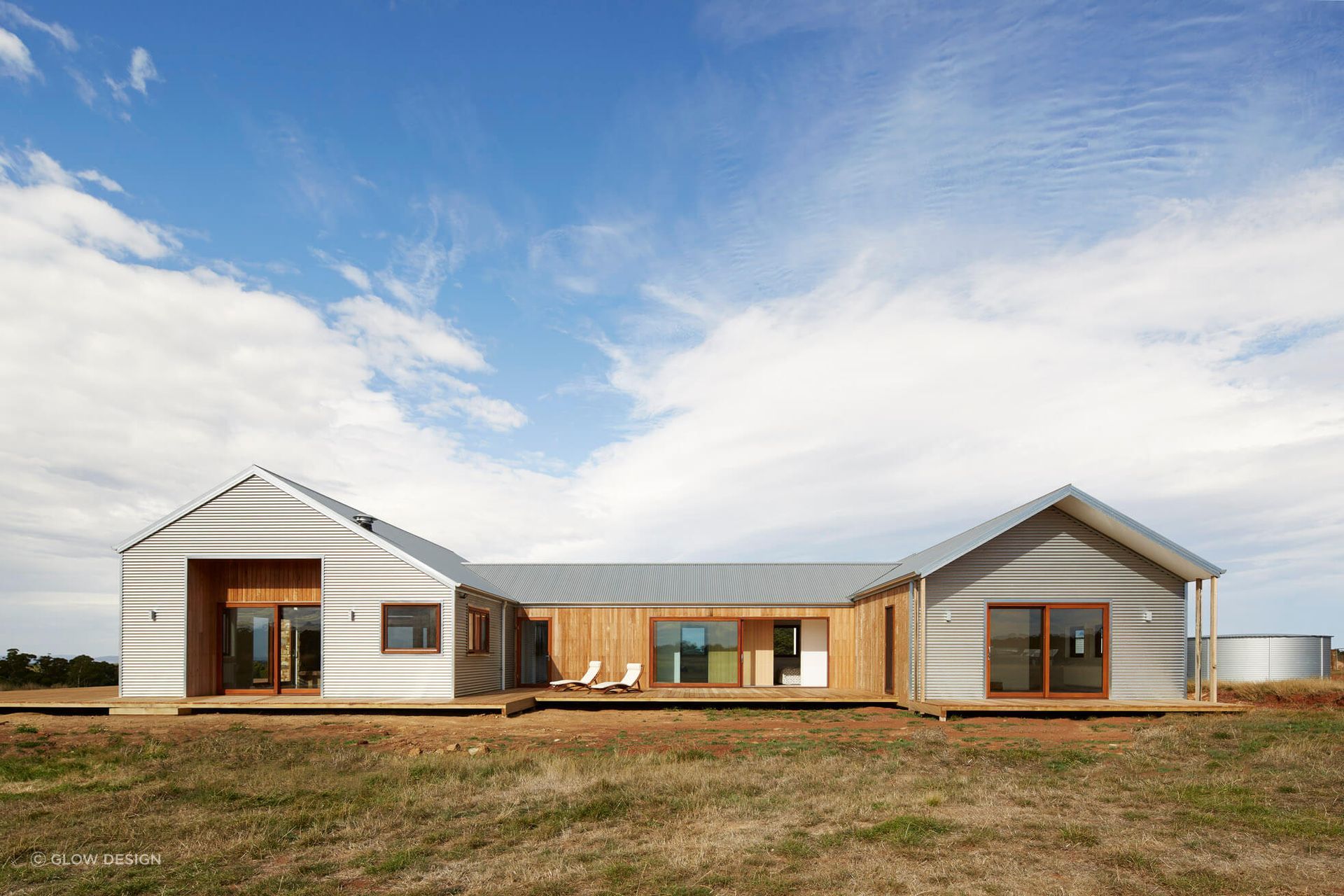 The pitched roof is designed for effective water collection into the tank, supporting sustainable living.