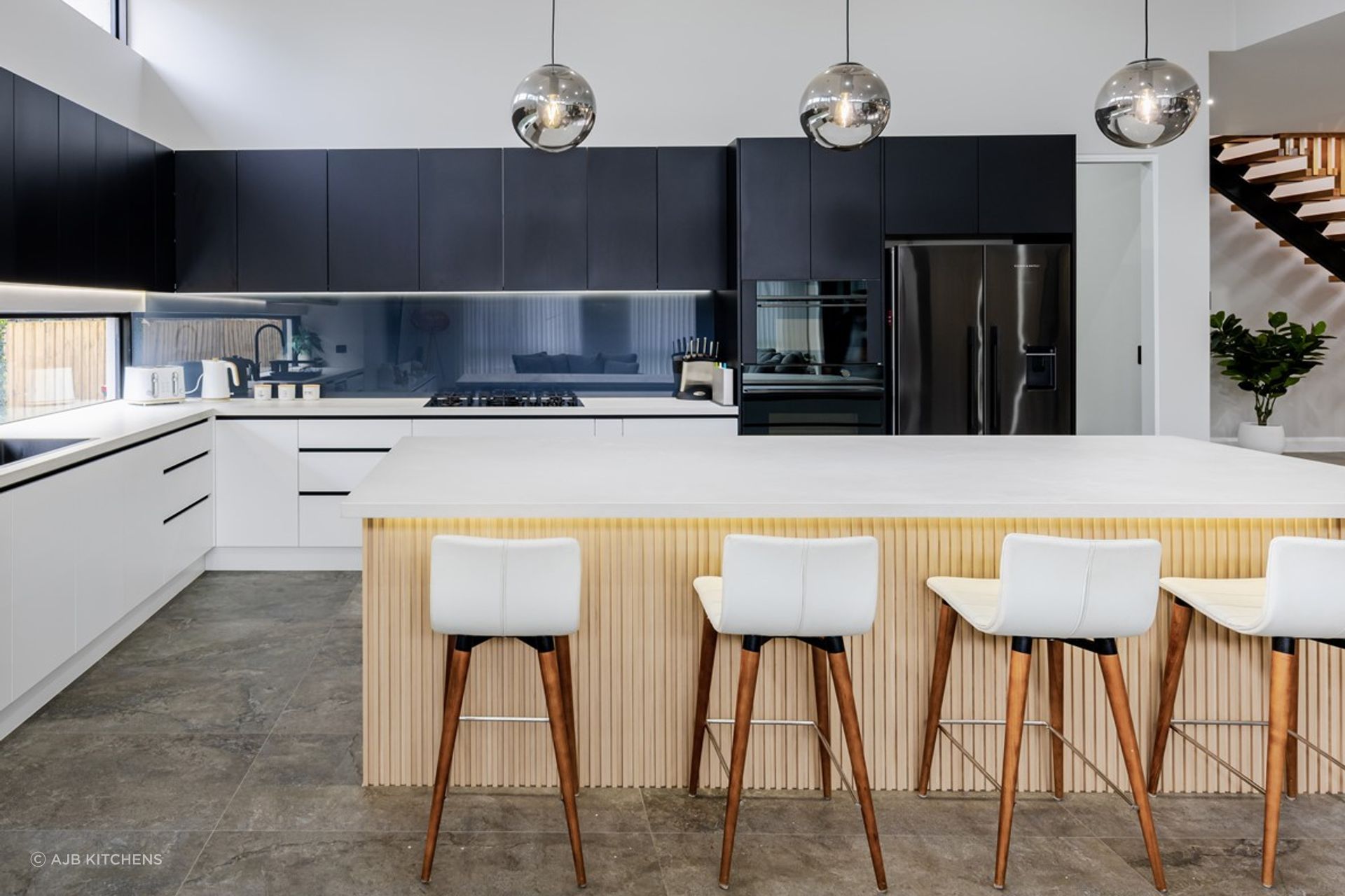 A stylish smoky mirror splashback in this luxury kitchen in Pennant Hills