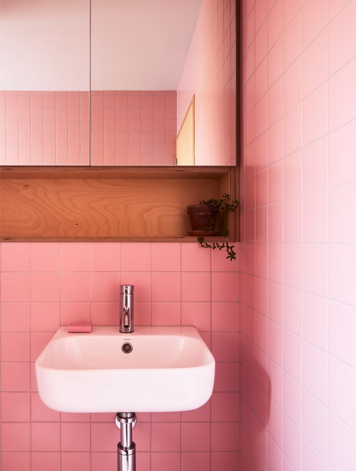 Pink bathroom tiles inject joy into everyday rituals.